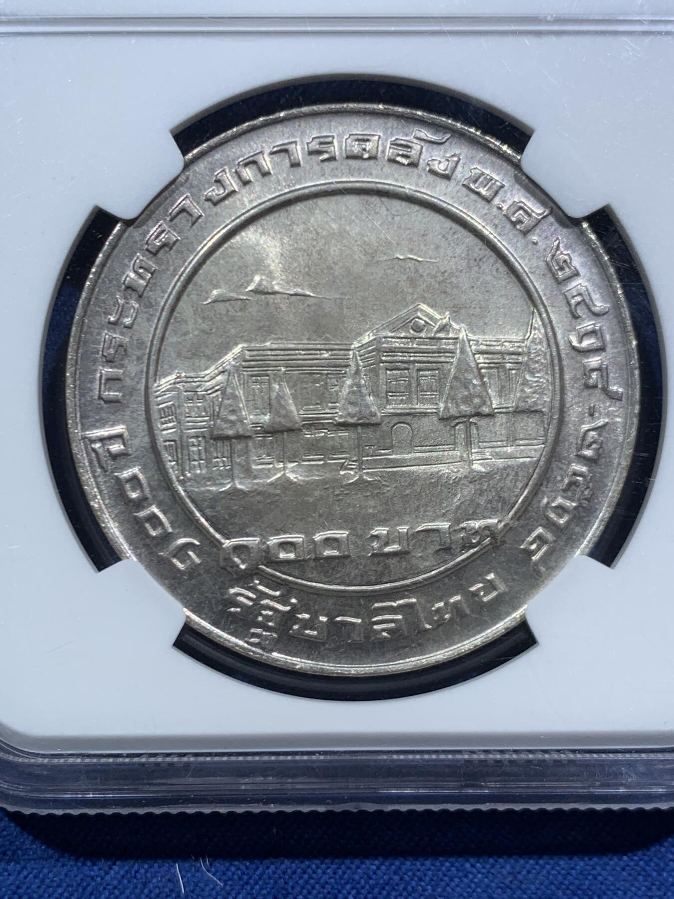 《竞宝斋》第466场 周日，周一 2场连拍 （全场包邮）欢迎送拍 NGC MS65 泰国1975年财政部成立120周年纪念银币，正面为国王普密蓬·阿杜德（拉玛九世）和当时的财政部长，象征着王室与政府部门的紧密合作，淡金色包浆保存极佳，100泰铢，25克，900银，发行量30020枚。