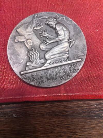 欧洲银章和银币 -  法国电力与燃气公司（EDF/GDF）服务纪念章解读 这是一枚由法国著名章牌雕刻家 亨利·德罗普西（Henri Dropsy, 1885-1969） 设计的镀银铜质纪念章，用于表彰在法国电力与燃气公司