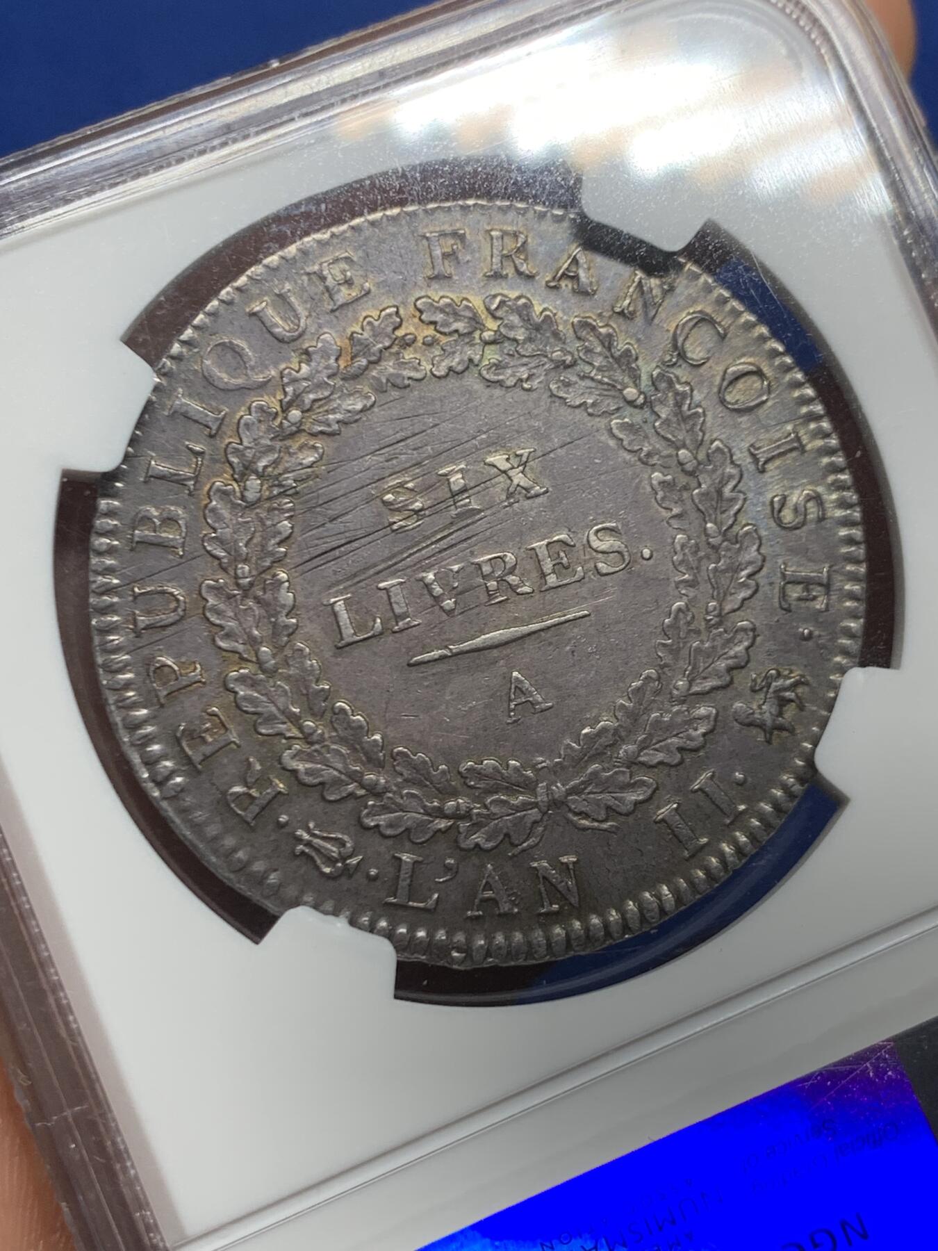 《竞宝斋》第467场 周日，周一 2场连拍 （全场包邮）欢迎送拍 名誉品 NGC AU58 天使埃居 法国国民公会时期1793年6里弗尔 少见好品，几乎未流通，深色均匀黑包浆，打制标准。铸造于国民公会时期(1792年9月21日-1795年10月26日)，持续时间很短，留存好品很少，此时路易十六已被斩首，因此正面由站立天使取代路易十六的头像，1793年为共和二年ANlI。