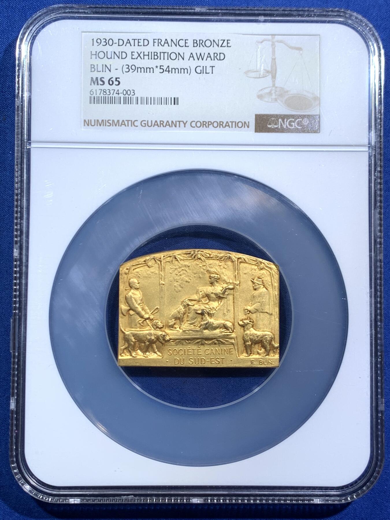 《竞宝斋》第467场 周日，周一 2场连拍 （全场包邮）欢迎送拍 NGC MS65 法国1930年猎犬博览会镀金异形大铜章，65顶级高分。中间坐姿女神与两边狗狗刻画生动精美，充分展现不同犬类的特征。加大盒封装，评级费就要二三百。状态绝佳，金水非常足，镀层状态极美。