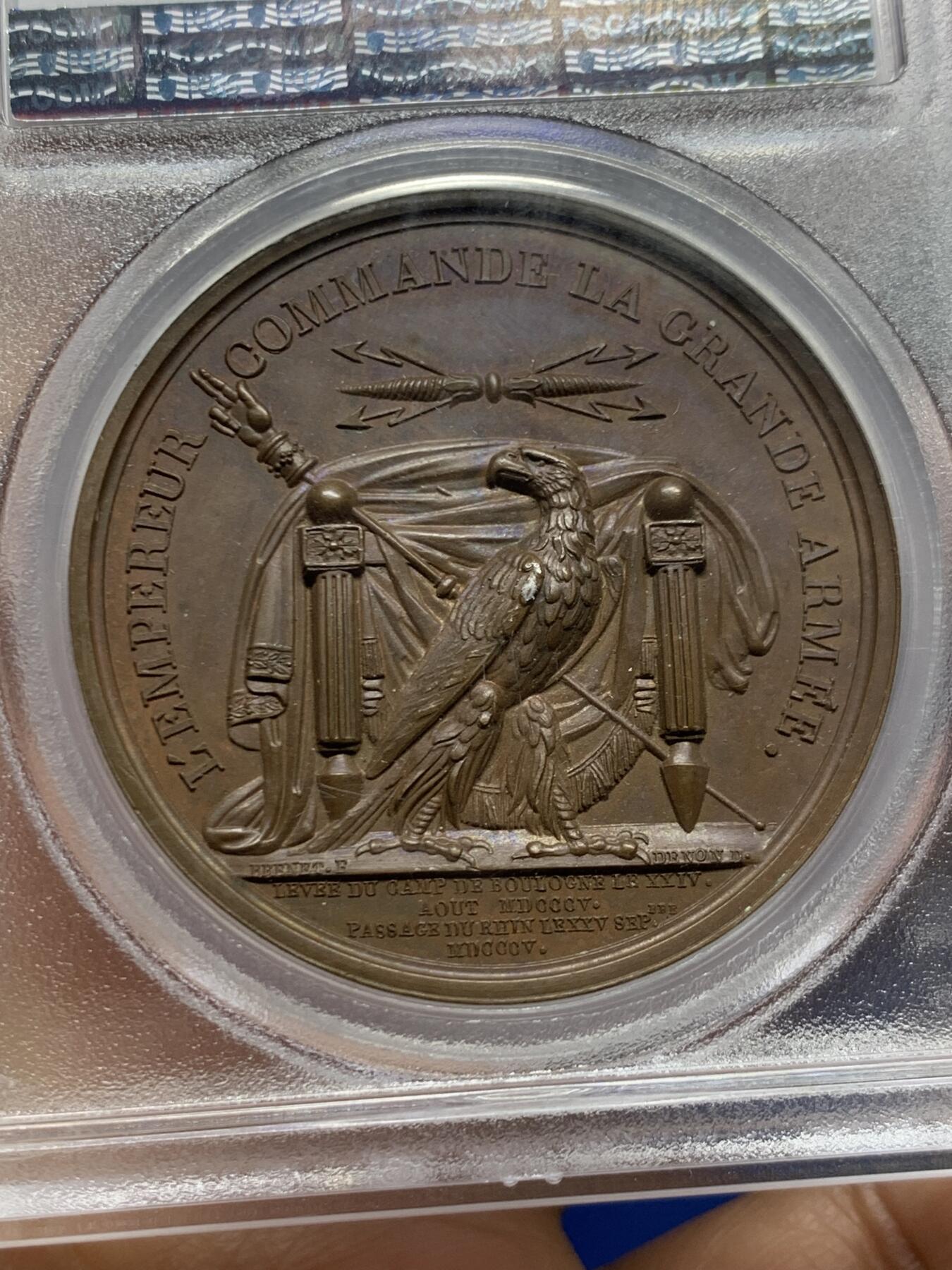 《竞宝斋》第467场 周日，周一 2场连拍 （全场包邮）欢迎送拍 PCGS SP64 亚军分！法国1805年拿破仑布洛涅大营原铸铜章 巴黎造币厂 巧克力包浆，王座上覆着拿皇加冕时的披风，帝国鹰坐于王座前目不转睛直盯着王座上方斜放的正义之手权杖，上方是一束闪电。传奇的布洛涅大营位于法国滨海，第一个营地由凯撒于公元前54年准备，为远征不列颠做准备舰队，第二个营地由拿破仑1803年建立，他在那里组建了“大军”，即海洋军，准备入侵英国，无愧凯撒的光荣传承人。加厚盒装