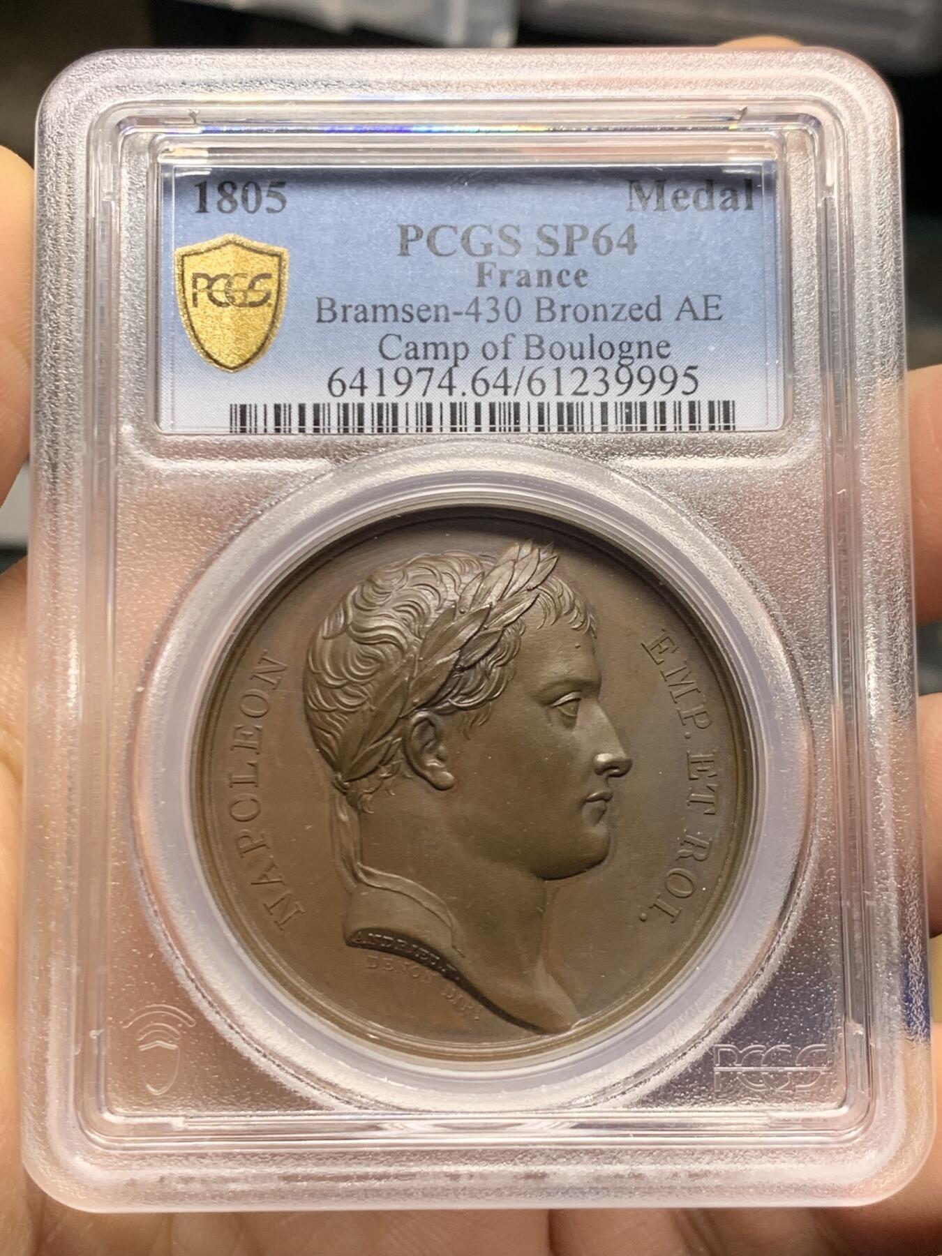 《竞宝斋》第467场 周日，周一 2场连拍 （全场包邮）欢迎送拍 PCGS SP64 亚军分！法国1805年拿破仑布洛涅大营原铸铜章 巴黎造币厂 巧克力包浆，王座上覆着拿皇加冕时的披风，帝国鹰坐于王座前目不转睛直盯着王座上方斜放的正义之手权杖，上方是一束闪电。传奇的布洛涅大营位于法国滨海，第一个营地由凯撒于公元前54年准备，为远征不列颠做准备舰队，第二个营地由拿破仑1803年建立，他在那里组建了“大军”，即海洋军，准备入侵英国，无愧凯撒的光荣传承人。加厚盒装