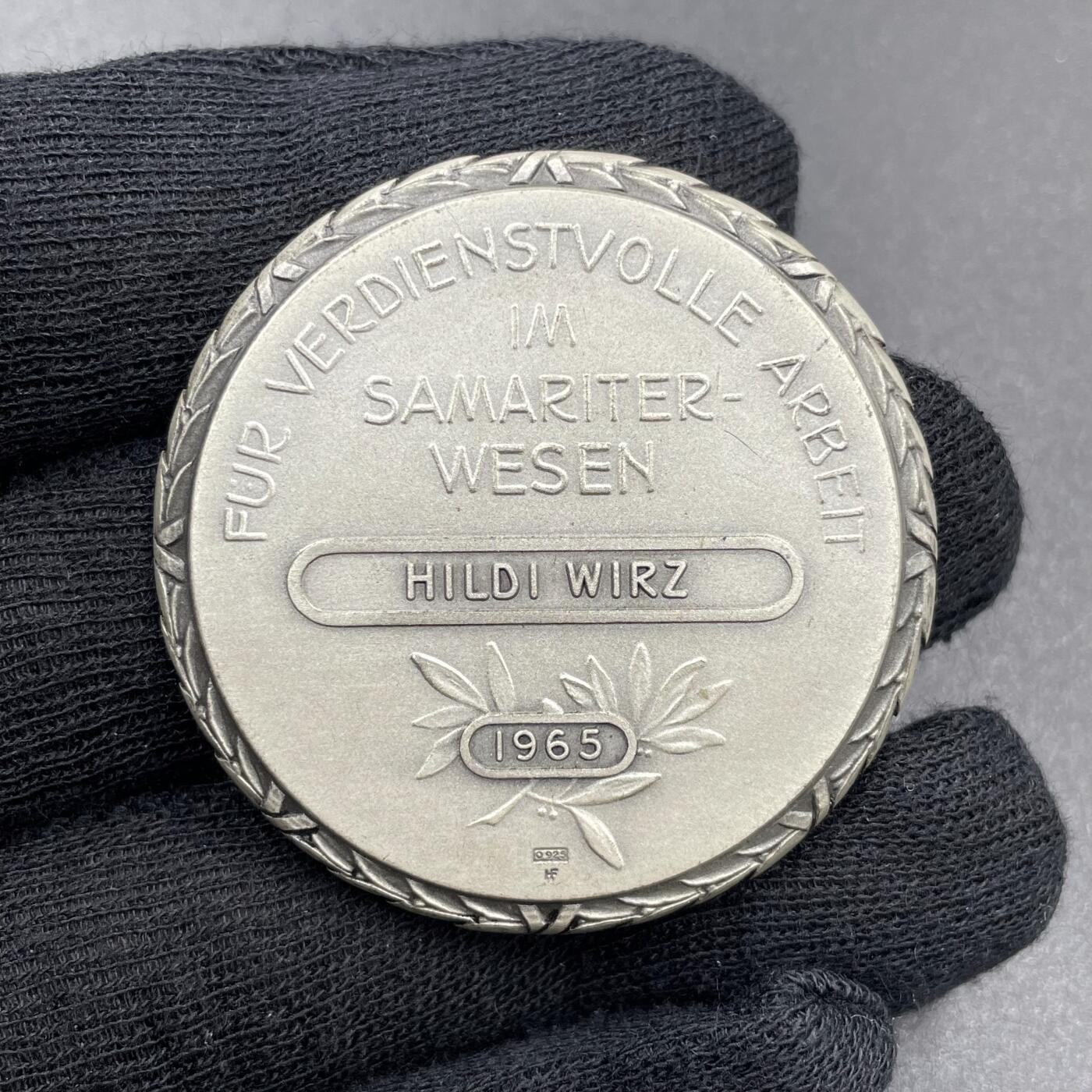 「木头集藏」章牌专场-第69场 Huguenin Frères～1965年瑞士红十字会撒玛利亚人联合会银章。直径：42mm，50.1g，背面下方标有含银量0.925和厂标HF，边缘的花边设计很有特色。  正面肖像是“红十字会之父”亨利·杜南（Henri Dunant，1828-1910年），他在1863年促成了国际红十字会的创立，1864年的《日内瓦公约》也是以他的思想为基础。