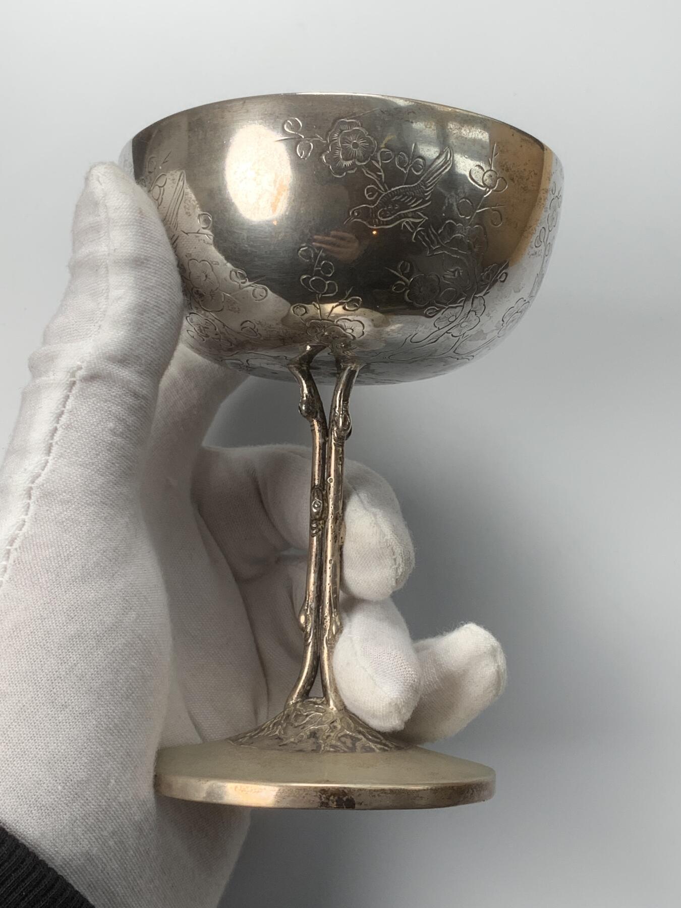 掌中浮雕-藏着的欧洲第053场 清末民初十三行联合银楼喜鹊登梅银杯，工艺很巧妙，杯柄做成了梅树树干，底座上浮雕了树根，杯壁上崭刻了梅花了喜鹊。纯银杯，底座内侧有标。luen-wo联合银楼，起源于广州十三行的粤帮银楼，1860-1920年代开设于上海。重量147.3克，高度12cm，口径8.7cm