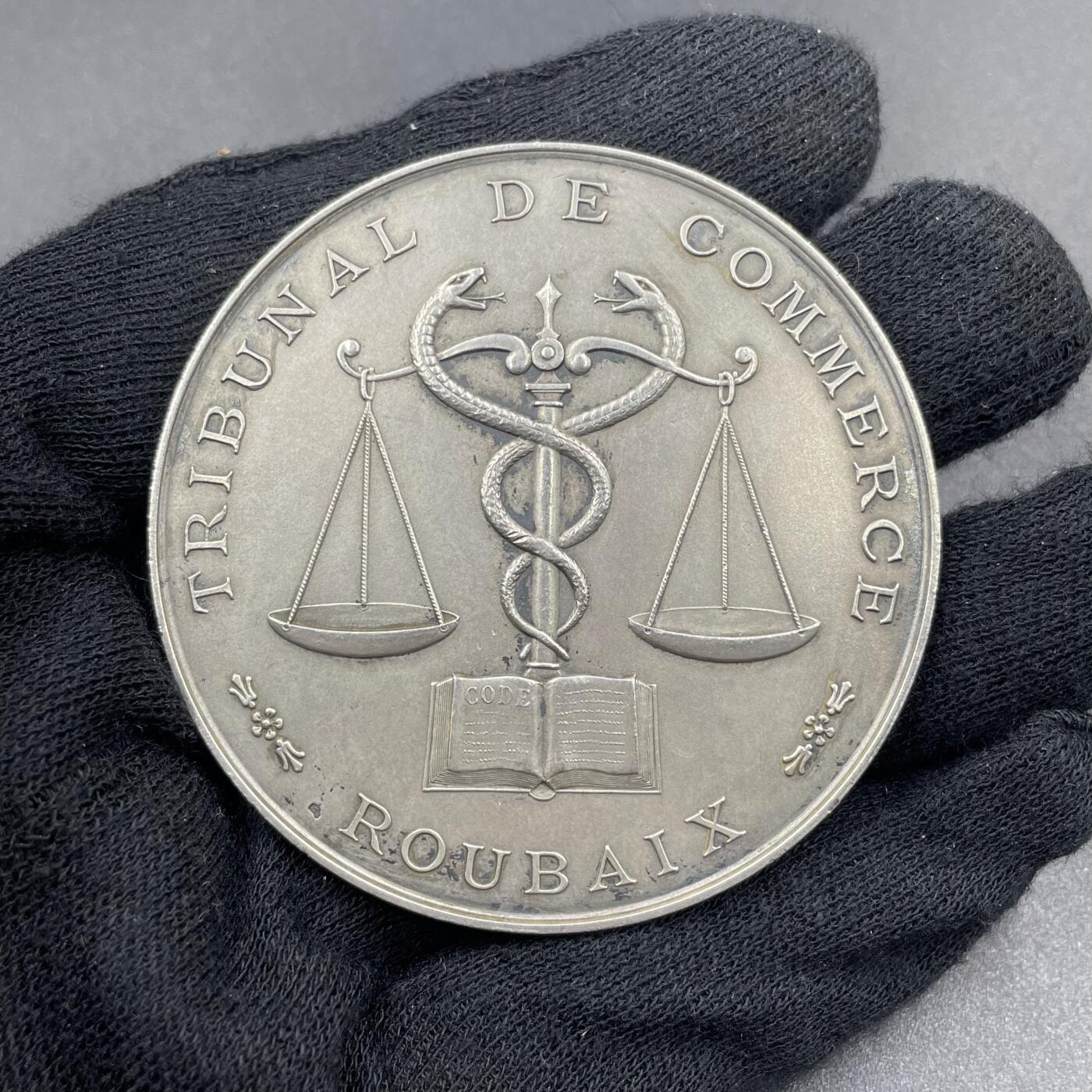 「木头集藏」章牌专场-第69场 1935年法国鲁贝商事法庭银奖章，直径：57 mm，75.1 g，边铭：菱形厂标 ARGENT，正面将代表商业的双蛇杖与象征公平的天平刻画在一起，代表着商事法庭在商业活动中维护公平与秩序的职责，背面刻字介绍获奖人Eugène Rasson 21年的职业生涯。少见银章，品相不错