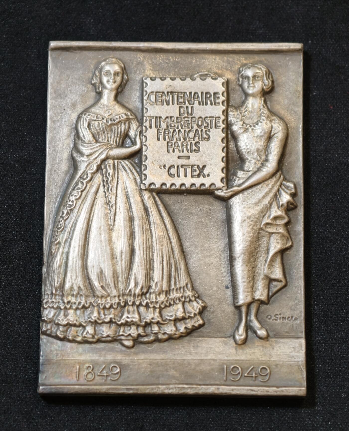 甄臻铺-世界币章拍卖（第53期），甄品场拍品征集中，送拍享返佣金等优惠多多 1949年法国邮政百年纪念银章，单面高浮雕，尺寸60.8毫米 x 43.8毫米，重93.2克，带原装盒子。正面是1849-1949百年纪念，两侧人物浮雕，背面无字，丰饶角1ARGENT边铭