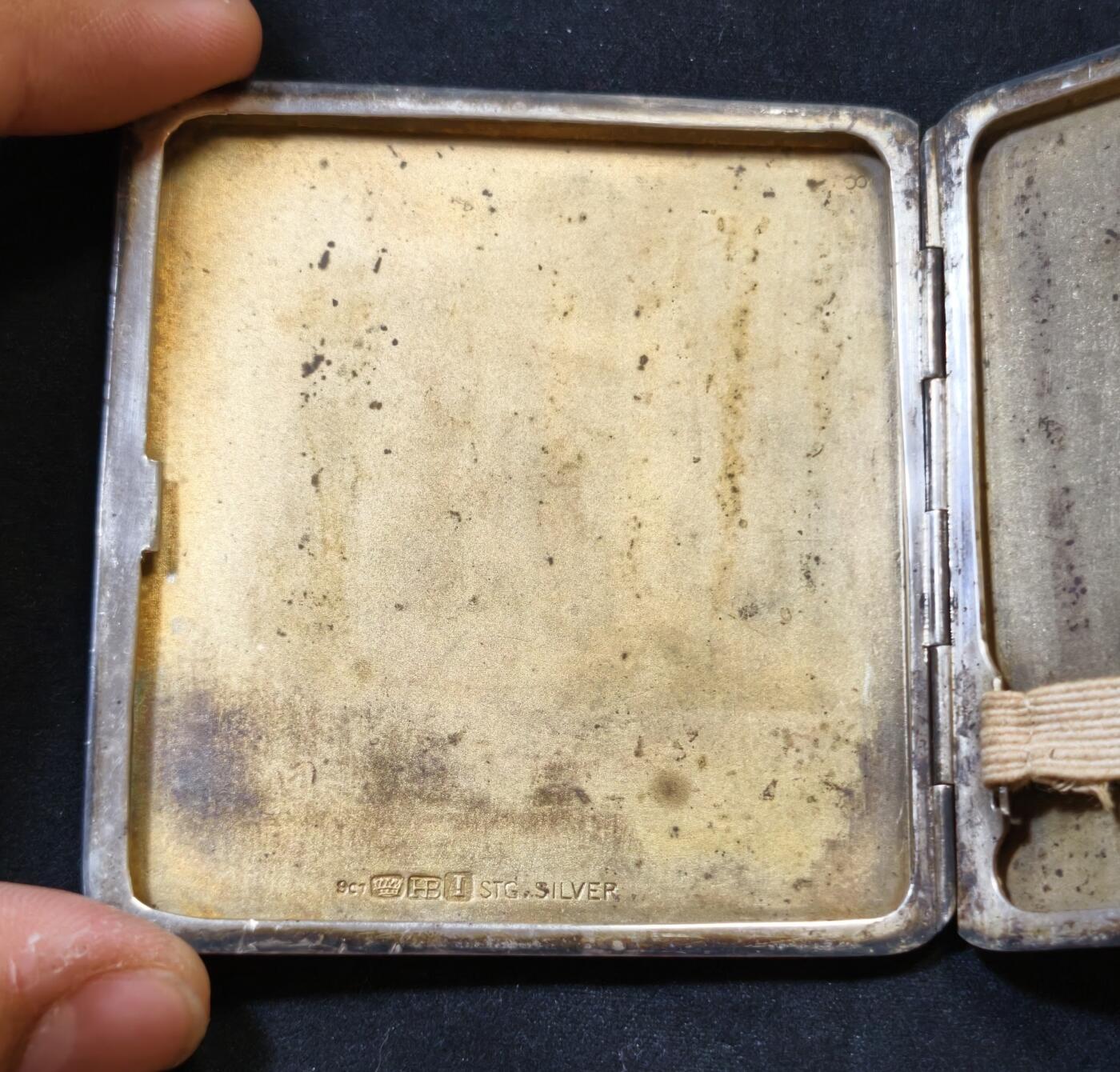 甄臻铺-世界币章拍卖（第53期），甄品场拍品征集中，送拍享返佣金等优惠多多 澳大利亚新南威尔士古董纯银嵌9k实金烟盒，澳大利亚新南威尔士纯银标记和9k金标记清晰齐全，1939年出品，925纯银。长7.6厘米，宽7厘米，重121.3克。盒面双面玑镂纹，精美大方，嵌9k金几何图标，并有原主人名Jevry铭刻。总体品相佳，能装7支短烟