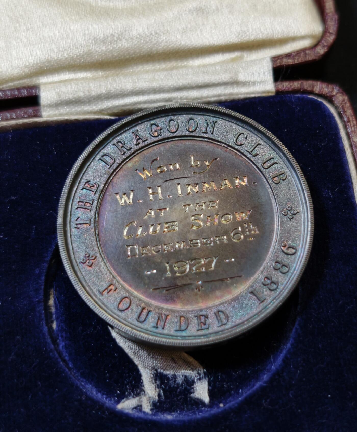 甄臻铺-世界币章拍卖（第53期），甄品场拍品征集中，送拍享返佣金等优惠多多 1927年英国龙骑士赛鸽俱乐部获奖银章，直径39毫米，重32克。正面雕刻三只鸽子图案，背面刻有W.H.Inman获奖字样。原装红皮盒，带内衬丝绒垫。表面自然氧化呈现五彩包浆，工艺精湛。边缘清晰，铭文完整，原装盒子完整