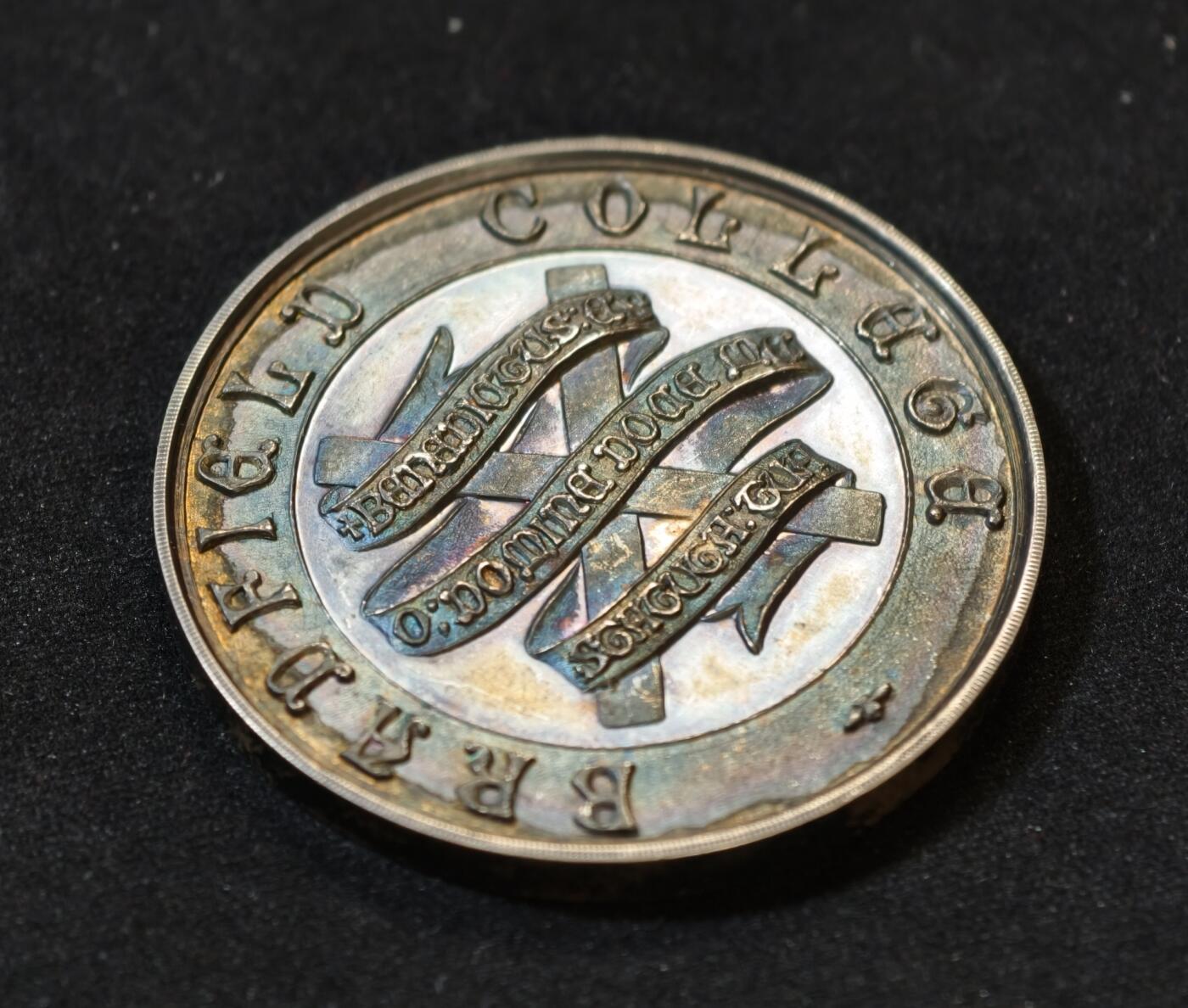 甄臻铺-世界币章拍卖（第53期），甄品场拍品征集中，送拍享返佣金等优惠多多 1917年英国布拉德菲尔德大学纪念银章，重25.8克，直径38.8毫米。正面刻有“Bradfield College”字样及校徽，背面是橄榄枝和奖章图案，银匠大师威廉姆詹姆斯丁利出品