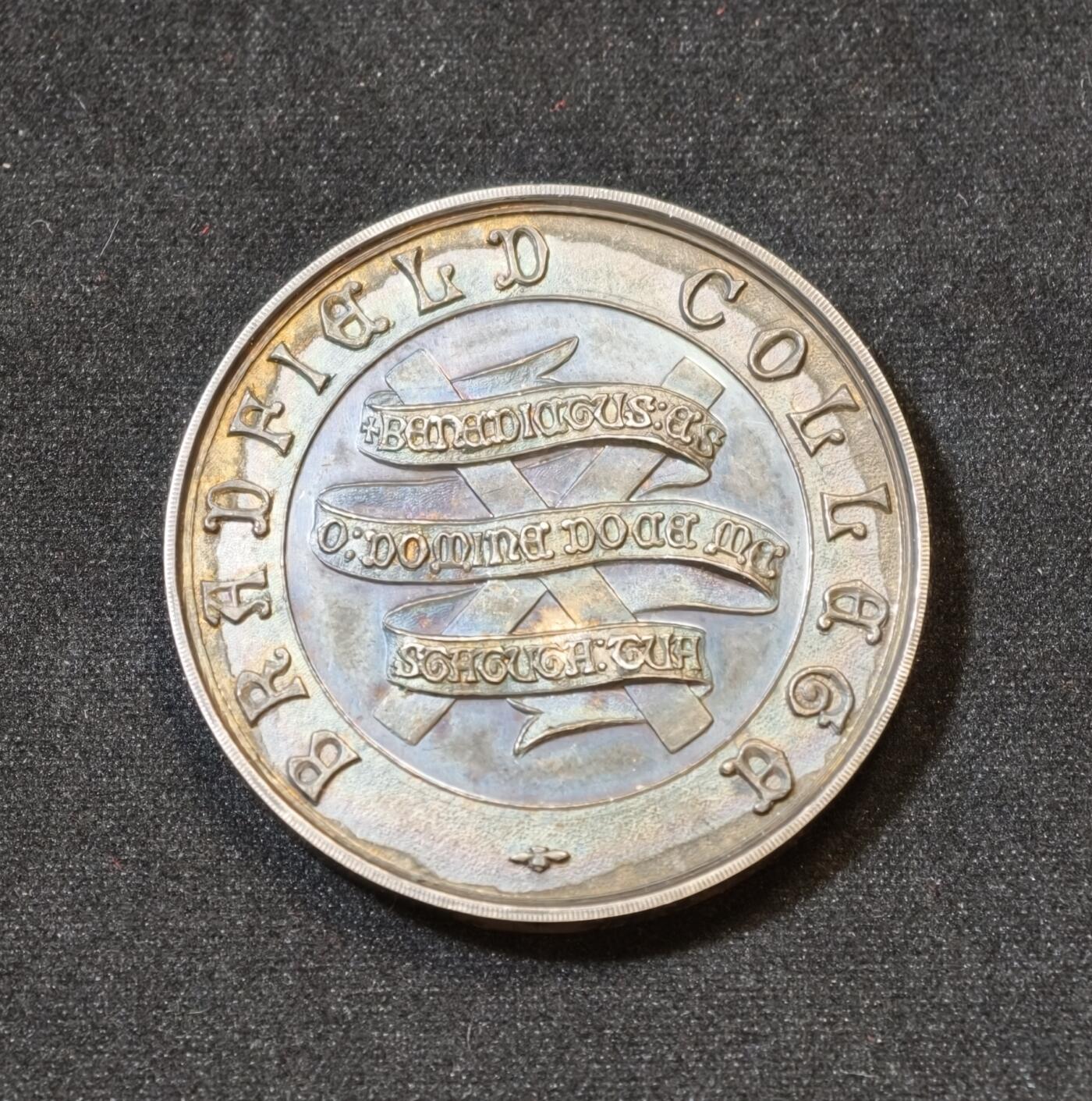 甄臻铺-世界币章拍卖（第53期），甄品场拍品征集中，送拍享返佣金等优惠多多 1917年英国布拉德菲尔德大学纪念银章，重25.8克，直径38.8毫米。正面刻有“Bradfield College”字样及校徽，背面是橄榄枝和奖章图案，银匠大师威廉姆詹姆斯丁利出品