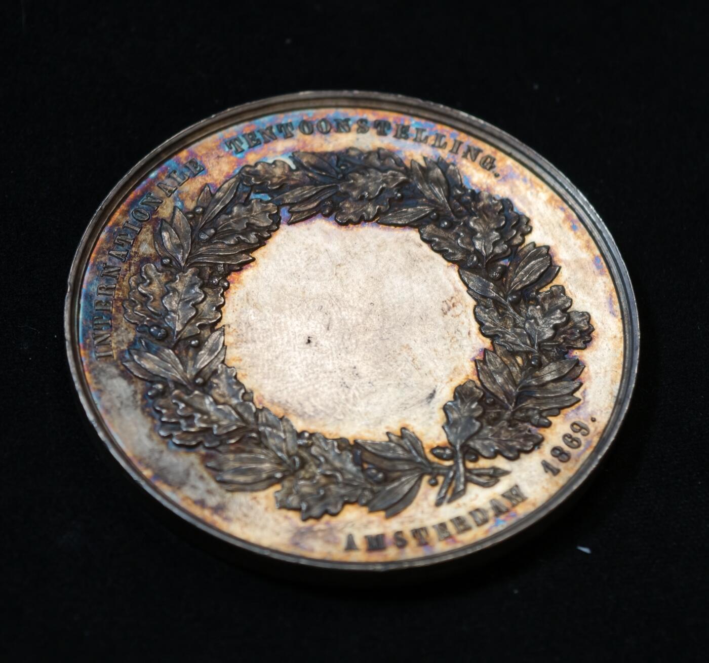 甄臻铺-世界币章拍卖（第53期），甄品场拍品征集中，送拍享返佣金等优惠多多 1869年荷兰阿姆斯特丹国际博览会银质纪念章，重54克，直径52.5毫米，五彩原包浆。正面是农业女神浮雕，背面环绕花环，刻有“AMSTERDAM 1869”字样，少见品种。