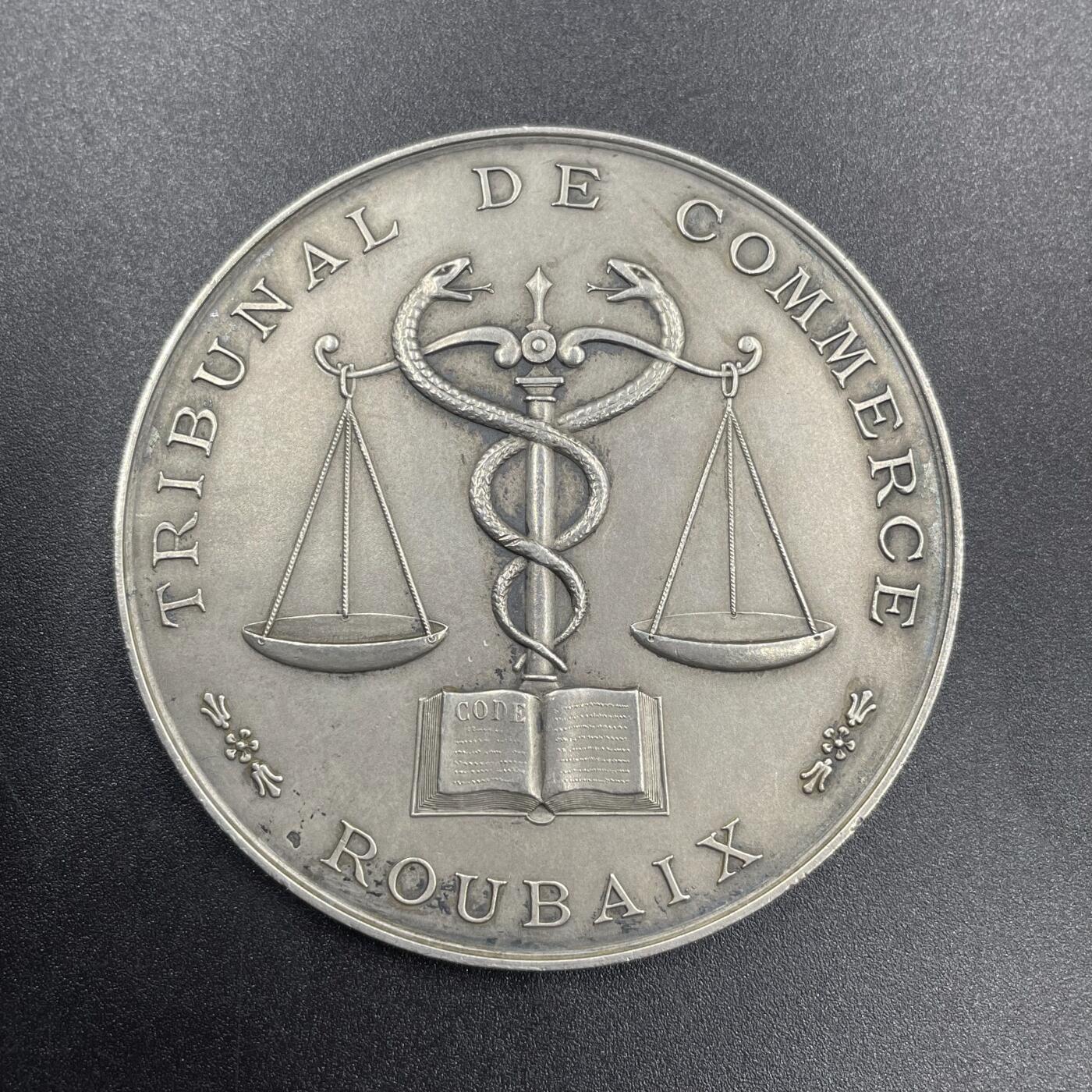「木头集藏」章牌专场-第69场 1935年法国鲁贝商事法庭银奖章，直径：57 mm，75.1 g，边铭：菱形厂标 ARGENT，正面将代表商业的双蛇杖与象征公平的天平刻画在一起，代表着商事法庭在商业活动中维护公平与秩序的职责，背面刻字介绍获奖人Eugène Rasson 21年的职业生涯。少见银章，品相不错