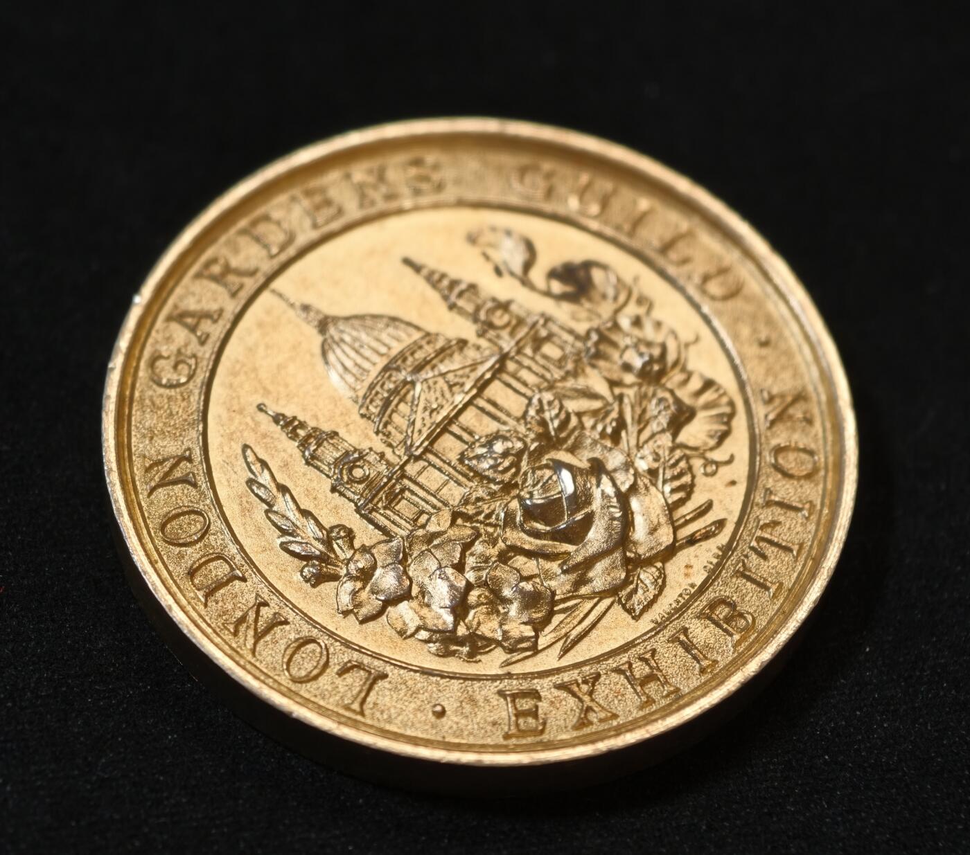 甄臻铺-世界币章拍卖（第53期），甄品场拍品征集中，送拍享返佣金等优惠多多 1931年伦敦园艺协会（London Gardens Guild）颁发的银质镀金纪念奖章，重30.391克，直径38.3毫米，原装蓝色绒面外盒。正面为协会建筑浮雕，背面花环装饰，无刻铭，带银标，大师沃顿斯作品。