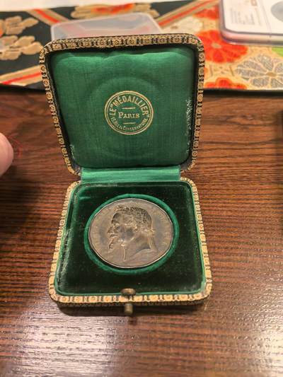 欧洲微章、铜章、银章和银币第二场 - 拿破仑三世农业竞赛纪念章50克法国第二帝国时期（1852-1870年）官方农业竞赛纪念章，具体信息 正面：刻有“NAPOLEON III EMPEREUR”（拿破仑三世皇帝）字样，是头戴月桂冠的拿破仑三世侧面像，由著名雕刻师阿尔丰斯·巴雷（Alphonse Barre）或其家族设计，意为“莫尔塔涅区农业竞赛”。图案是由羊、牛、马头和犁组成的农业花环，中心为空白，用于镌刻获奖者姓名。