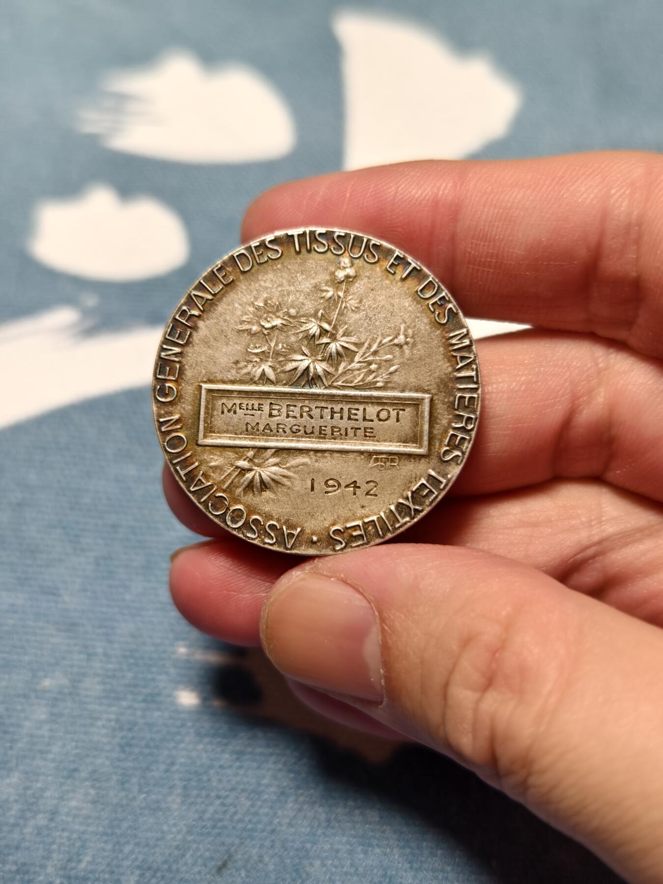 抚柳草堂-第十四期章牌钱币  奖章勋章限时免佣 满百包邮 放漏专场 1942法国纺织品和纺织材料总协会镀银大铜章  直径36mm   21.4g 正面高浮雕了工人操作纺织机的场景 是法国新艺术风格工业题材章牌的典型设计 由雕刻师 A. Rive 创作 