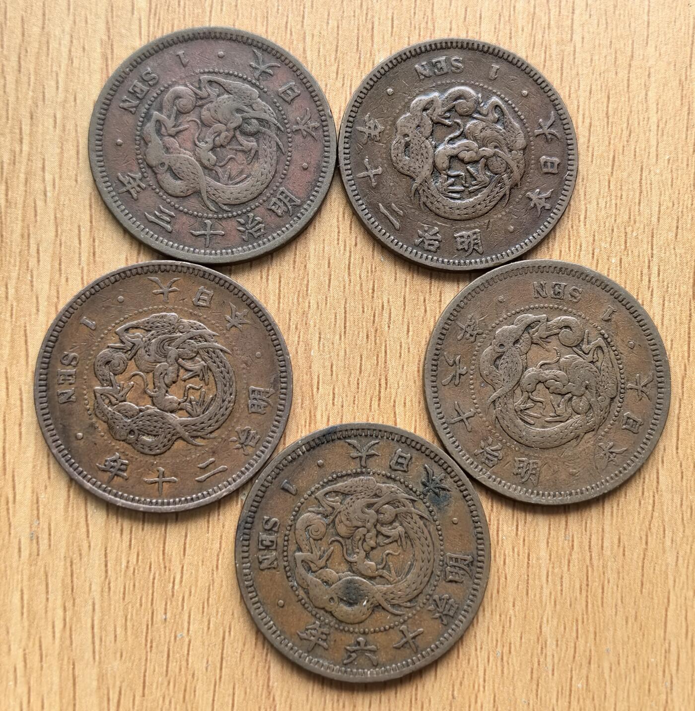 外国优质老铜币银币苏联纪念章，每周六晚九点倒数截拍，满百包邮可寄存，持续收拍 日本明治时期一钱铜币5枚明治十三年-明治二十年，是明治维新后推行近代货币改革的产物。1871 年《新货条例》确立 “圆 - 钱 - 厘” 十进制体系，1873 年起正式发行，正面龙纹象征皇权，背面 “一钱” 与兑换比例体现其辅币属性，是日本近代化的重要见证。