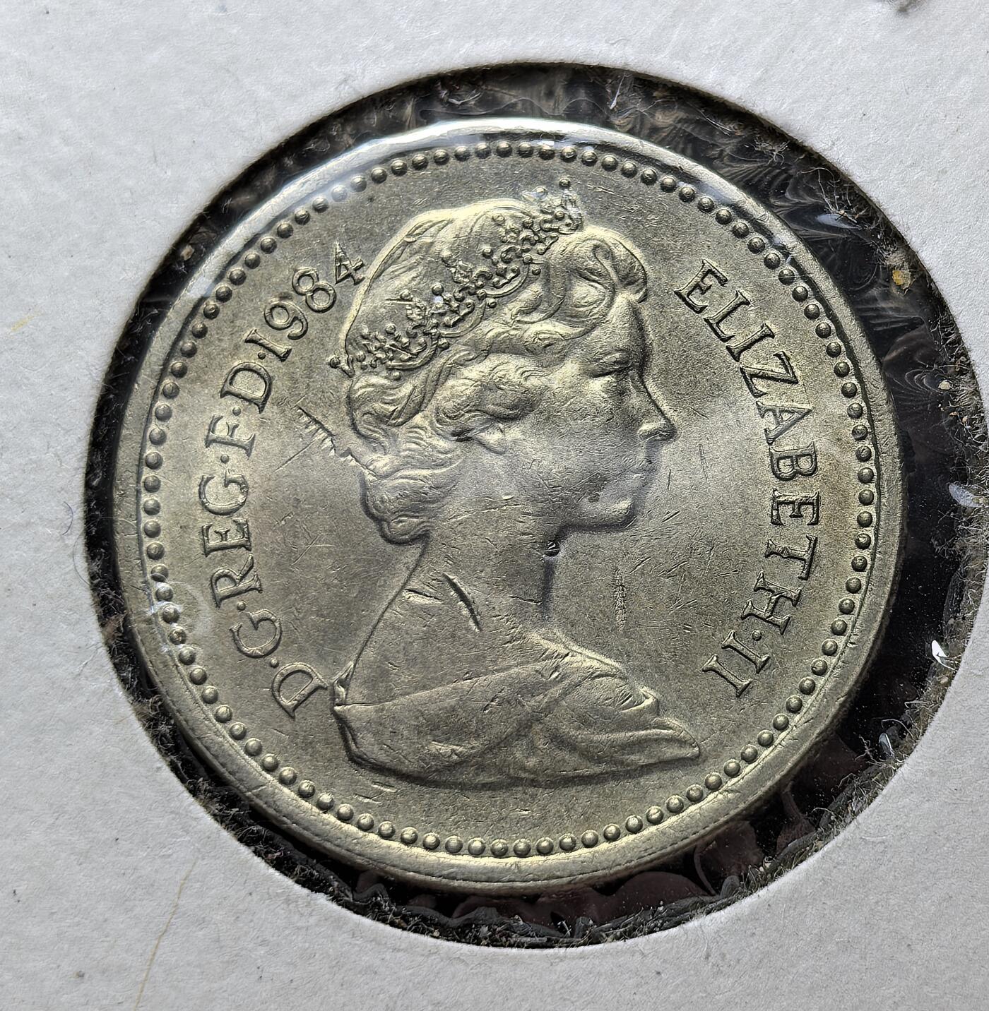 外国优质老铜币银币苏联纪念章，每周六晚九点倒数截拍，满百包邮可寄存，持续收拍 好品英国地区英镑花卉系列首枚背面蓟花配王冠象征苏格兰，蓟花是苏格兰国花，边缘刻有 “无人可犯我而不受惩” 的格言，正面为伊丽莎白二世头像。