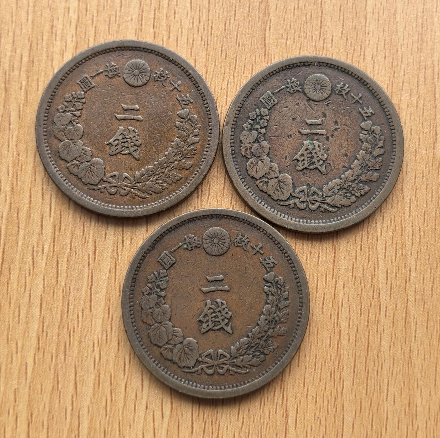 外国优质老铜币银币苏联纪念章，每周六晚九点倒数截拍，满百包邮可寄存，持续收拍 日本明治时期的二钱铜币3枚，铸造于明治14年至 16年（1881–1883 年），是明治维新后推行 “円・銭・厘” 十进制币制的产物，由大阪造币局生产，正面铸龙纹，背面为 “二钱” 与菊花纹，是近代日本货币体系转型的重要见证。