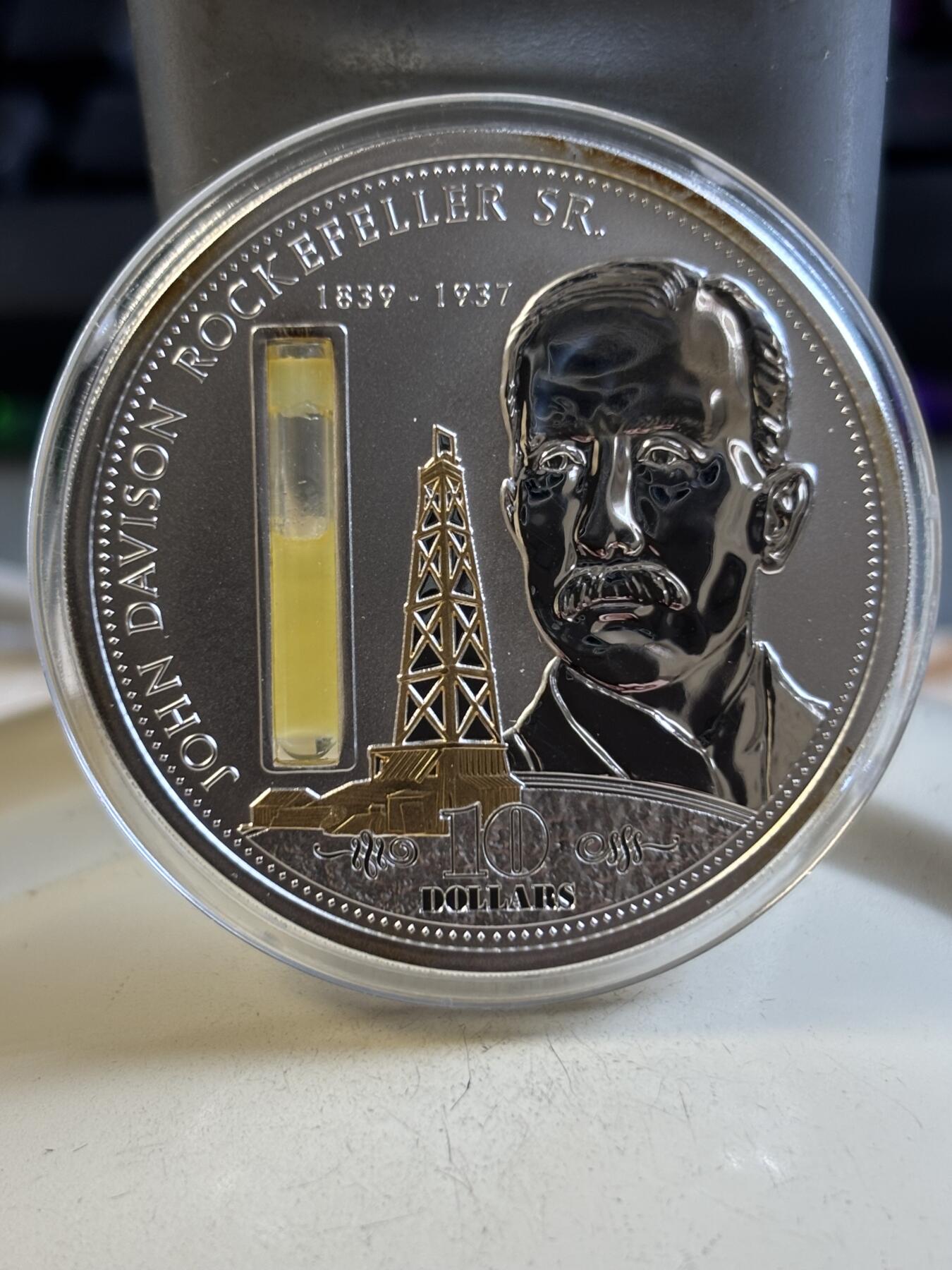 第193期拍卖 库克2009年金融大亨约翰洛克菲勒镶嵌石油纪念银币，999银，塑料盒有破