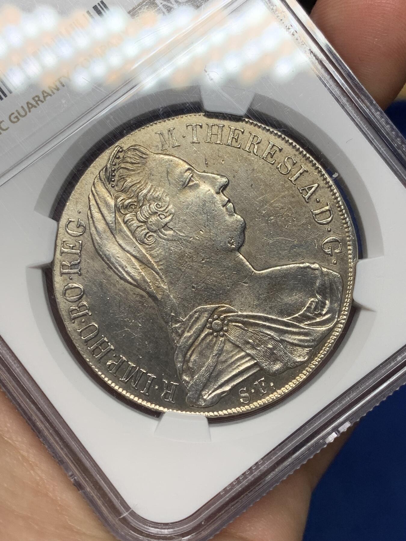 《竞宝斋》第468场 周日，周一 2场连拍 （全场包邮）欢迎送拍 NGC AU 少见1815至1828年米兰版玛丽亚特蕾莎贸易银币经典“中心正圆九珍珠”披风针，目录编号：哈夫纳36a。该版本为女皇逝世后，为了迎合近中东贸易货币使用习惯，由奥属意大利米兰造币厂铸造的版本，主要流通于北非、中东地区，是历史上真正参与流通的行用币！背面为减重痕。