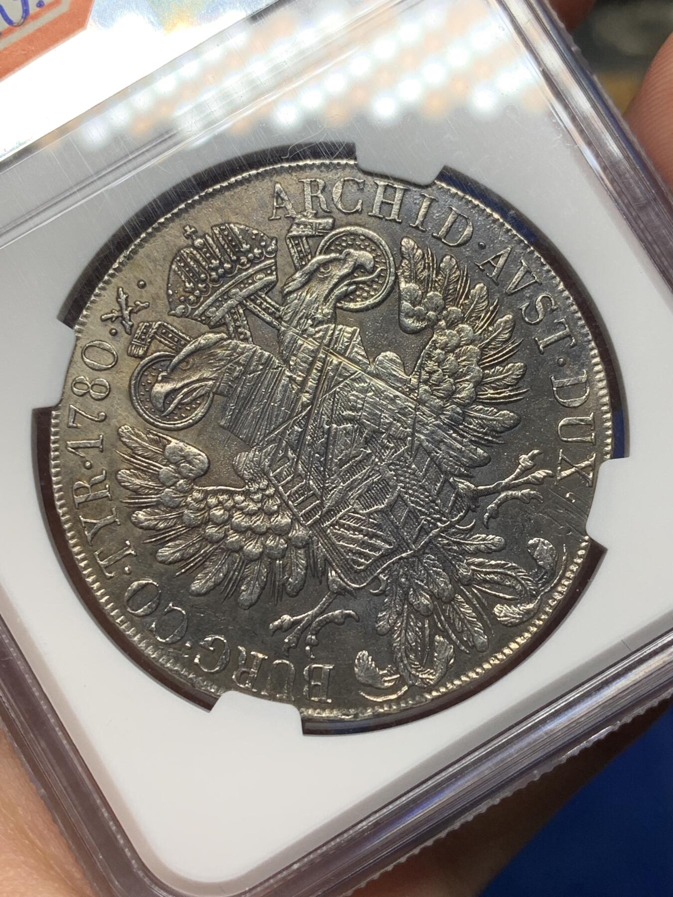 《竞宝斋》第468场 周日，周一 2场连拍 （全场包邮）欢迎送拍 NGC AU 少见1815至1828年米兰版玛丽亚特蕾莎贸易银币经典“中心正圆九珍珠”披风针，目录编号：哈夫纳36a。该版本为女皇逝世后，为了迎合近中东贸易货币使用习惯，由奥属意大利米兰造币厂铸造的版本，主要流通于北非、中东地区，是历史上真正参与流通的行用币！背面为减重痕。