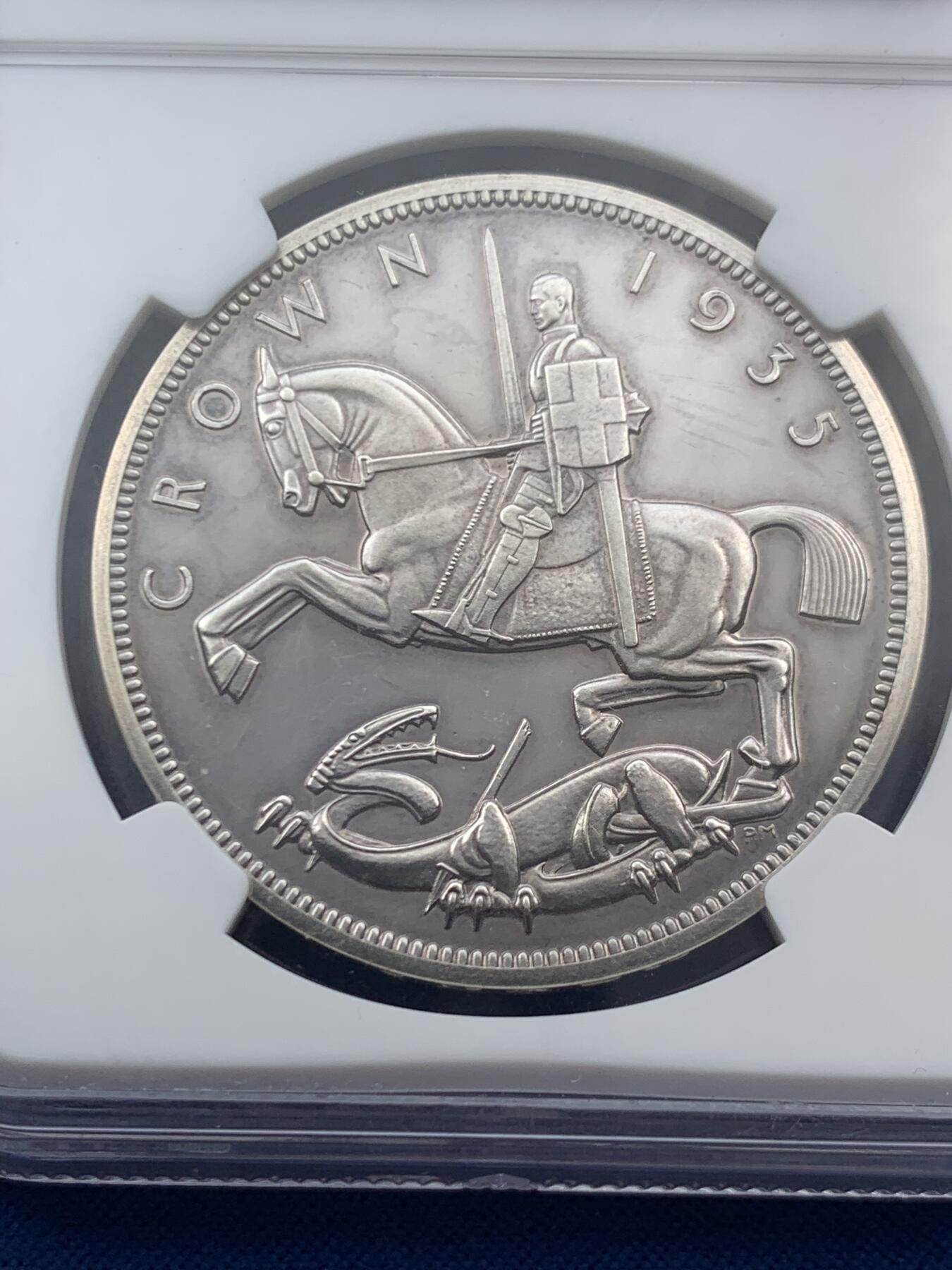 《竞宝斋》第469场 周日，周一 2场连拍 （全场包邮）欢迎送拍 NGC PF61 英国1935年乔治五世精制木马剑屠龙克朗 发行量仅2500枚的精制克朗 未沿用Pistrucci经典圣乔治屠龙 其偏向现代主义风格的屠龙武士更像是游乐场里的旋转木马 故戏称木马剑 925高银 镜面高浮雕