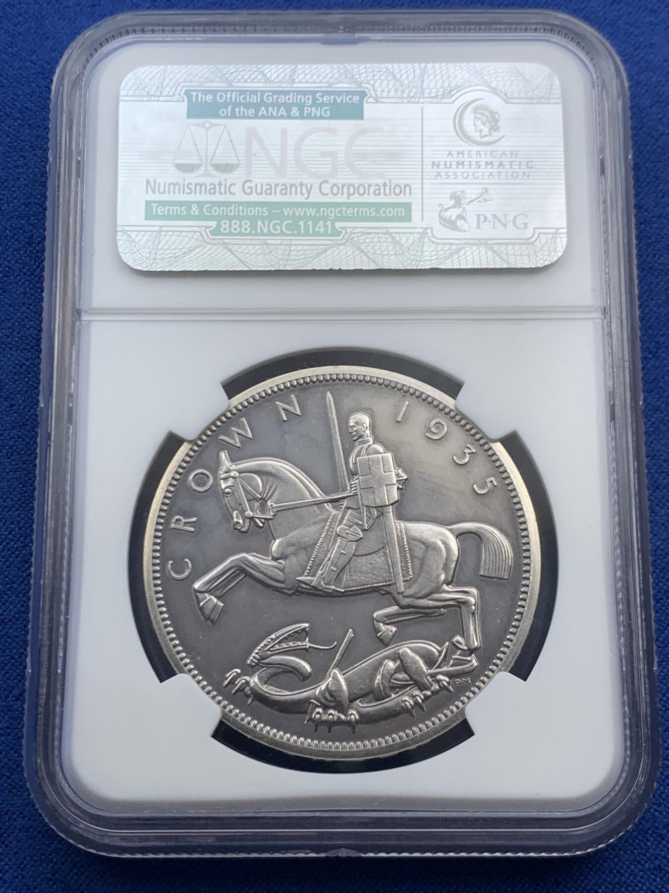 《竞宝斋》第469场 周日，周一 2场连拍 （全场包邮）欢迎送拍 NGC PF61 英国1935年乔治五世精制木马剑屠龙克朗 发行量仅2500枚的精制克朗 未沿用Pistrucci经典圣乔治屠龙 其偏向现代主义风格的屠龙武士更像是游乐场里的旋转木马 故戏称木马剑 925高银 镜面高浮雕