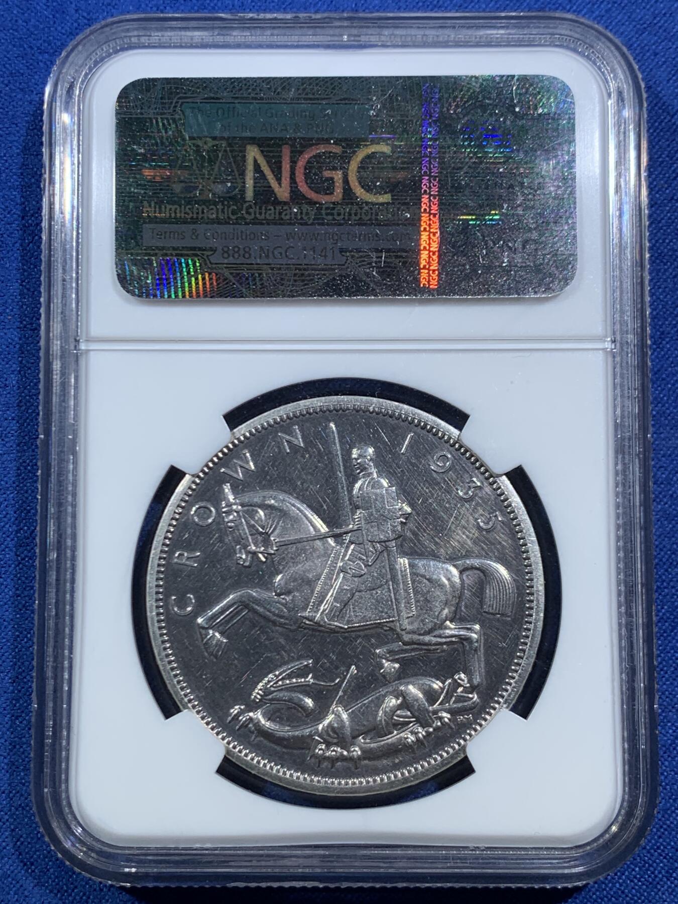 《竞宝斋》第469场 周日，周一 2场连拍 （全场包邮）欢迎送拍 NGC PF61 英国1935年乔治五世精制木马剑屠龙克朗 发行量仅2500枚的精制克朗 未沿用Pistrucci经典圣乔治屠龙 其偏向现代主义风格的屠龙武士更像是游乐场里的旋转木马 故戏称木马剑 925高银 镜面高浮雕