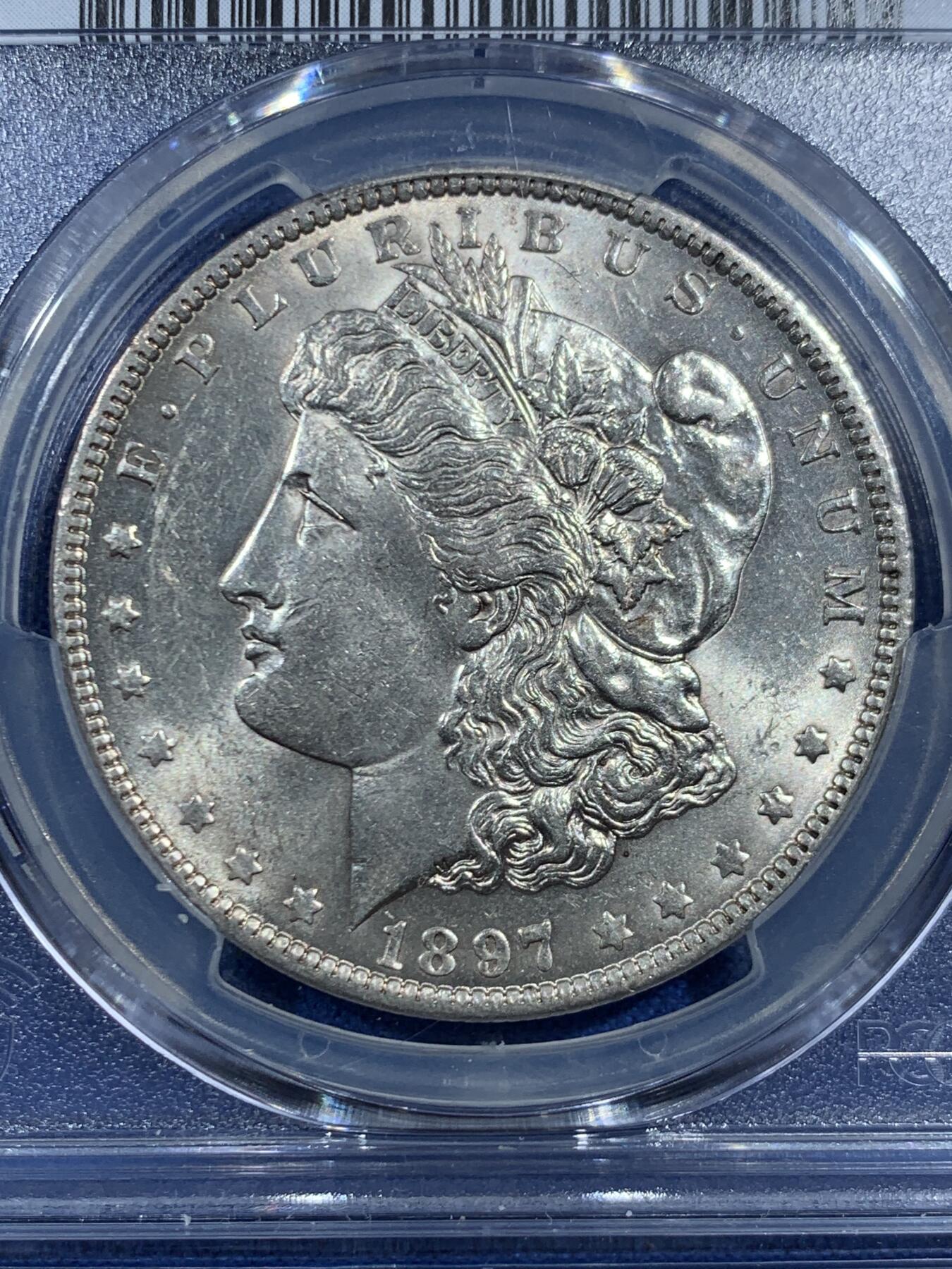 《竞宝斋》第469场 周日，周一 2场连拍 （全场包邮）欢迎送拍 PCGS AU58 美国 1897 O 摩根银币 此年份摩根大量钱币於法案中被融毁 因此好品难寻 麦稀奇首见如此高分稀有钱币 此币乃收藏中必不可少的一环 转光犀利 PCGS指导价3991