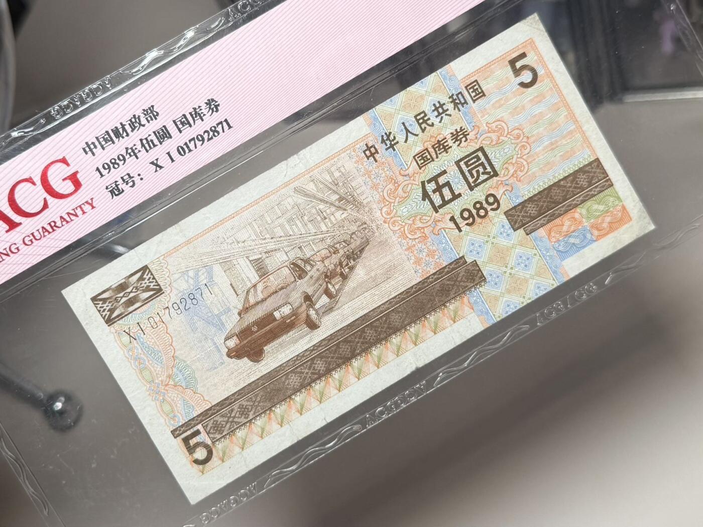 【乾奕收藏】1989年中华人民共和国国库券伍圆，大众汽车生产线图案，爱藏评级40分。年代久远加之纸质收藏品保存难度大，评级币一切以分数为准，售出非假不退