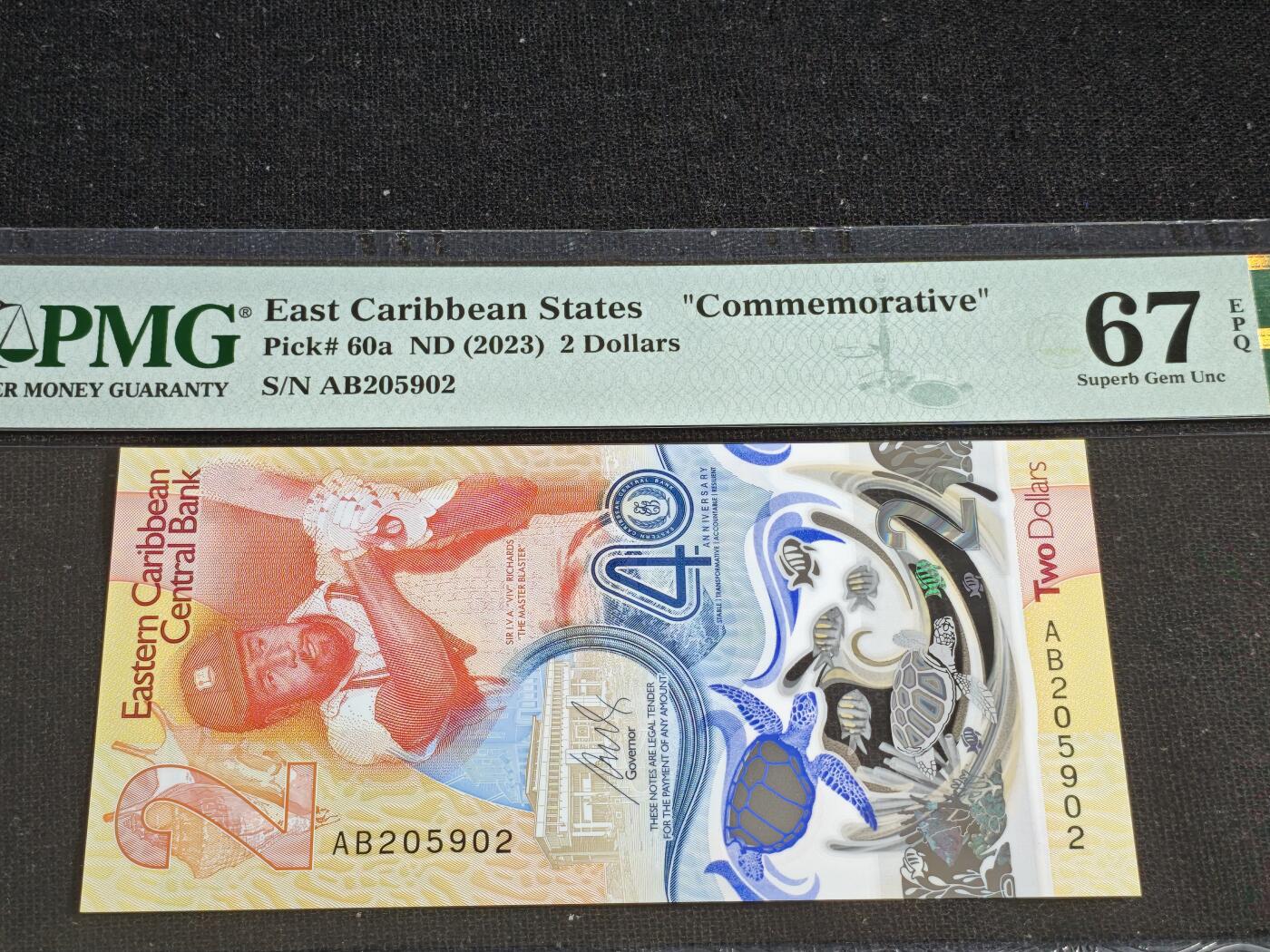 刘世昌艺术品销售中心～虎踞龙蟠*金杨在线联拍群第519期 东加勒比2023年“央行成立40周年”2元纪念钞（PMG   67E   号码：AB205902）1枚。此币荣获当年IBNS“世界最佳纸币”大奖。