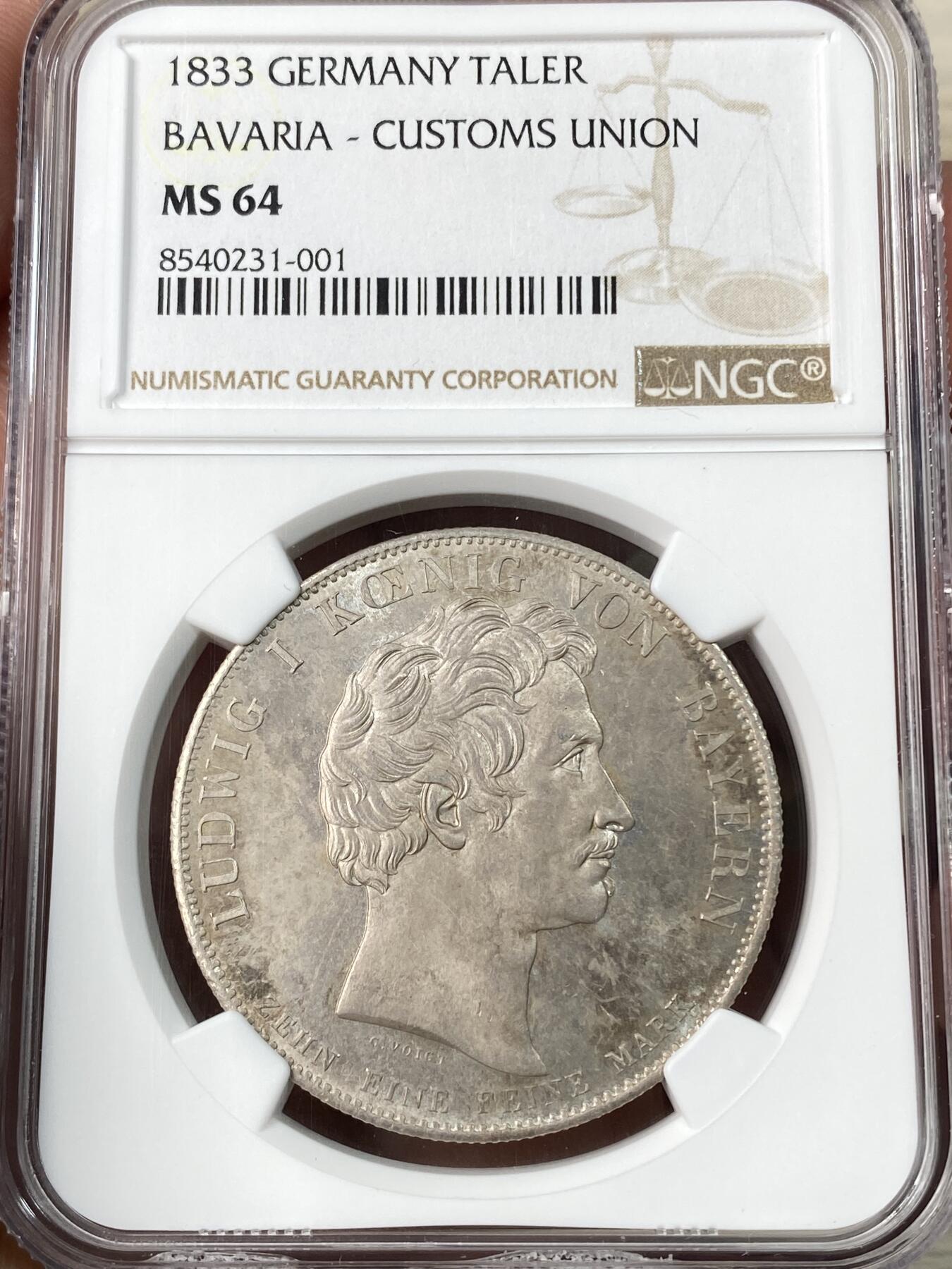 万国钱币拍卖第062期 PCGS MS64 1833巴伐利亚路德维希一世关税同盟历史大泰勒 在历史泰勒四枚关税同盟系列中好品最为罕见的品种 人格化的巴伐利亚女神着一席长袍 左手举丰饶角 右手持墨丘利权杖 寓意新的关税同盟带来贸易与财富 原味欧陆五彩裹身 邮票光泽底板 无可挑剔的一枚典藏级历史大泰勒