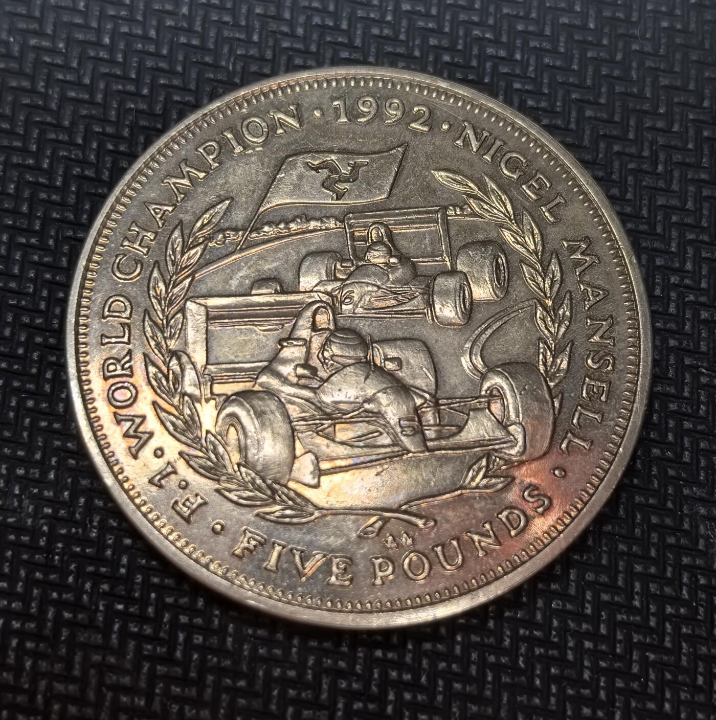 外国优质老铜币银币苏联纪念章，每周六晚九点倒数截拍，满百包邮可寄存，持续收拍 马恩岛1993年5英镑纪念币，为纪念奈杰尔・曼塞尔夺得1992年F1世界冠军而铸造。正面为伊丽莎白二世头像，背面刻有 F1 赛车与冠军字样，由英国 Pobjoy 造币厂制作