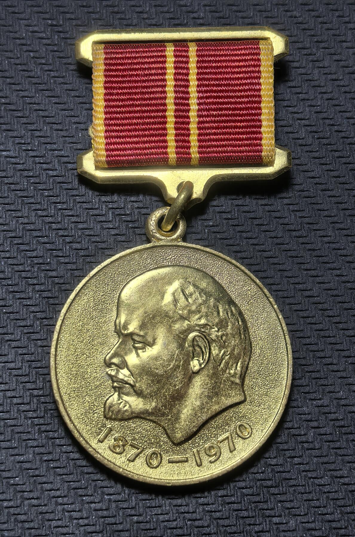 外国优质老铜币银币苏联纪念章，每周六晚九点倒数截拍，满百包邮可寄存，持续收拍 苏联列宁诞辰100周年(1870-1970)纪念章含绶带，27克总长64mm章直径32mm，非流通货币。正面为列宁头像，背面铭文表彰 “英勇劳动”，是苏联为纪念革命导师百年华诞、宣扬意识形态权威而颁发的荣誉象征，集中体现了那个时代的政治文化氛围。