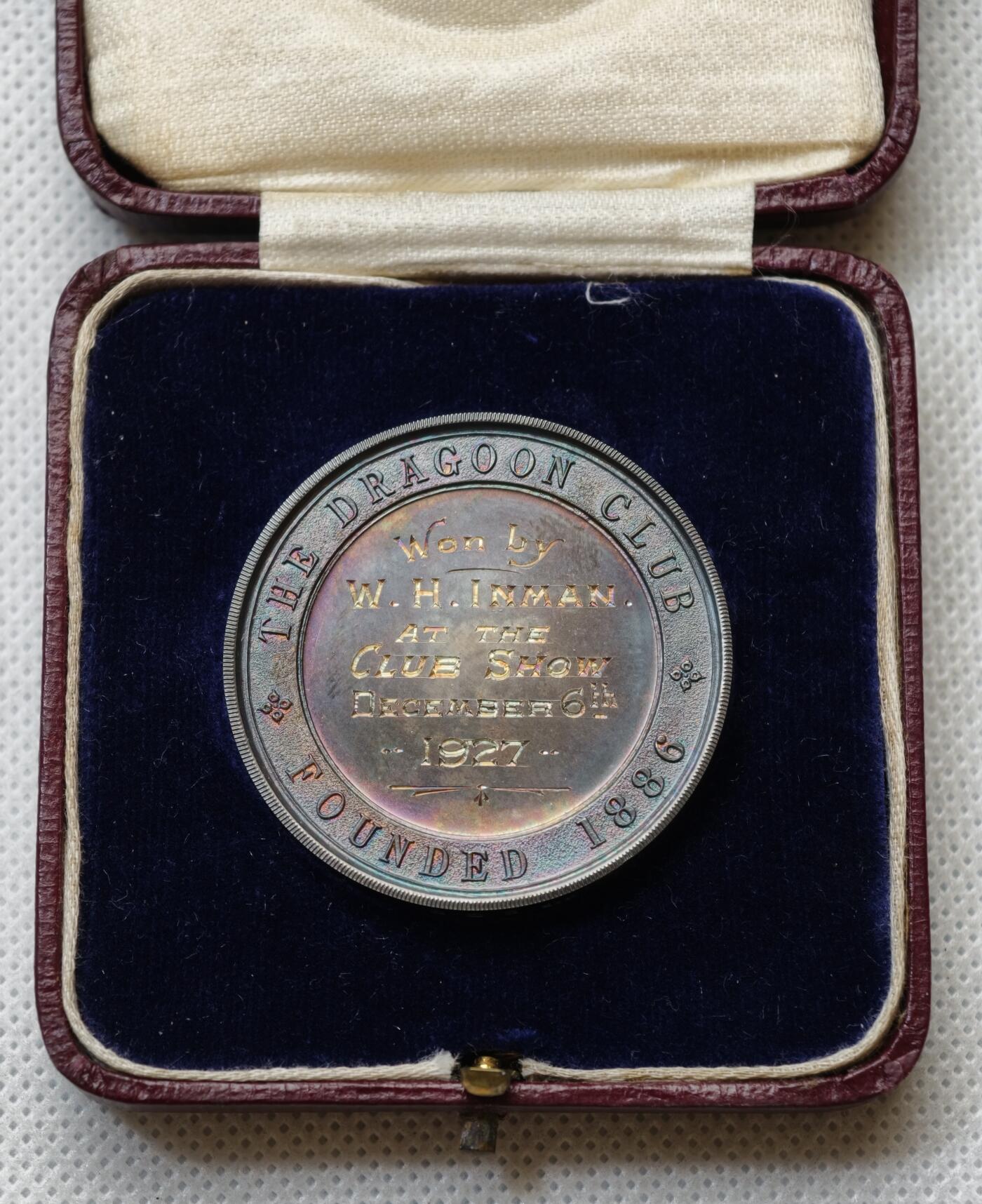 甄臻铺-世界币章拍卖（第54期），3月28日甄品场拍品征集中，送拍享返佣金等优惠多多 1927年英国龙骑士赛鸽俱乐部获奖银章，直径39毫米，重32克。正面雕刻三只鸽子图案，背面刻有W.H.Inman获奖字样。原装红皮盒，带内衬丝绒垫。表面自然氧化呈现五彩包浆，工艺精湛。边缘清晰，铭文完整，原装盒子完整（鸽子重拍）