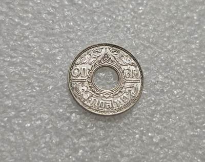 瓶子🏺第232期拍卖会 -  泰国1941年10萨当（Satang）圆孔银币  正面 中心为圆孔，周围环绕泰式卷草纹与尖顶佛塔纹，是暹罗传统艺术的典型符号。 泰文铭文： ๑๐ สตางค์ （10 Satang），下方为 ราชอาณาจักรไทย （泰王国） 背面 中心为圆孔，外圈是莲花瓣/火焰纹（象征佛教与王室），内圈为泰文纪年与造币厂标记（ ๒๔๘๔  即佛历2484年，对应公元1941年）