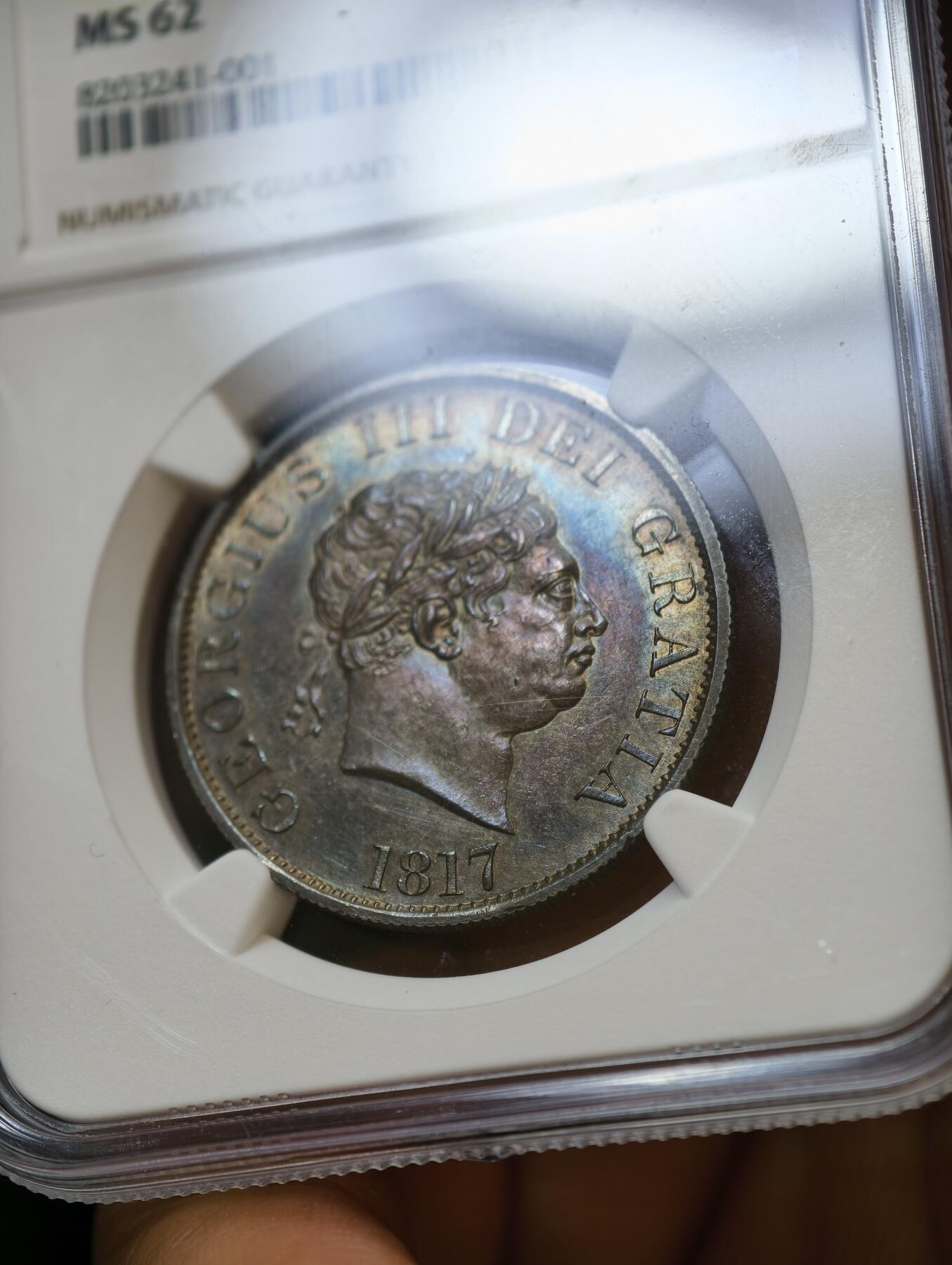 甄臻铺-世界币章拍卖（第54期），3月28日甄品场拍品征集中，送拍享返佣金等优惠多多 NGC-MS62 大英帝国1817年乔治三世牛头半克朗，黑五彩！实物上手令人惊艳的包浆。