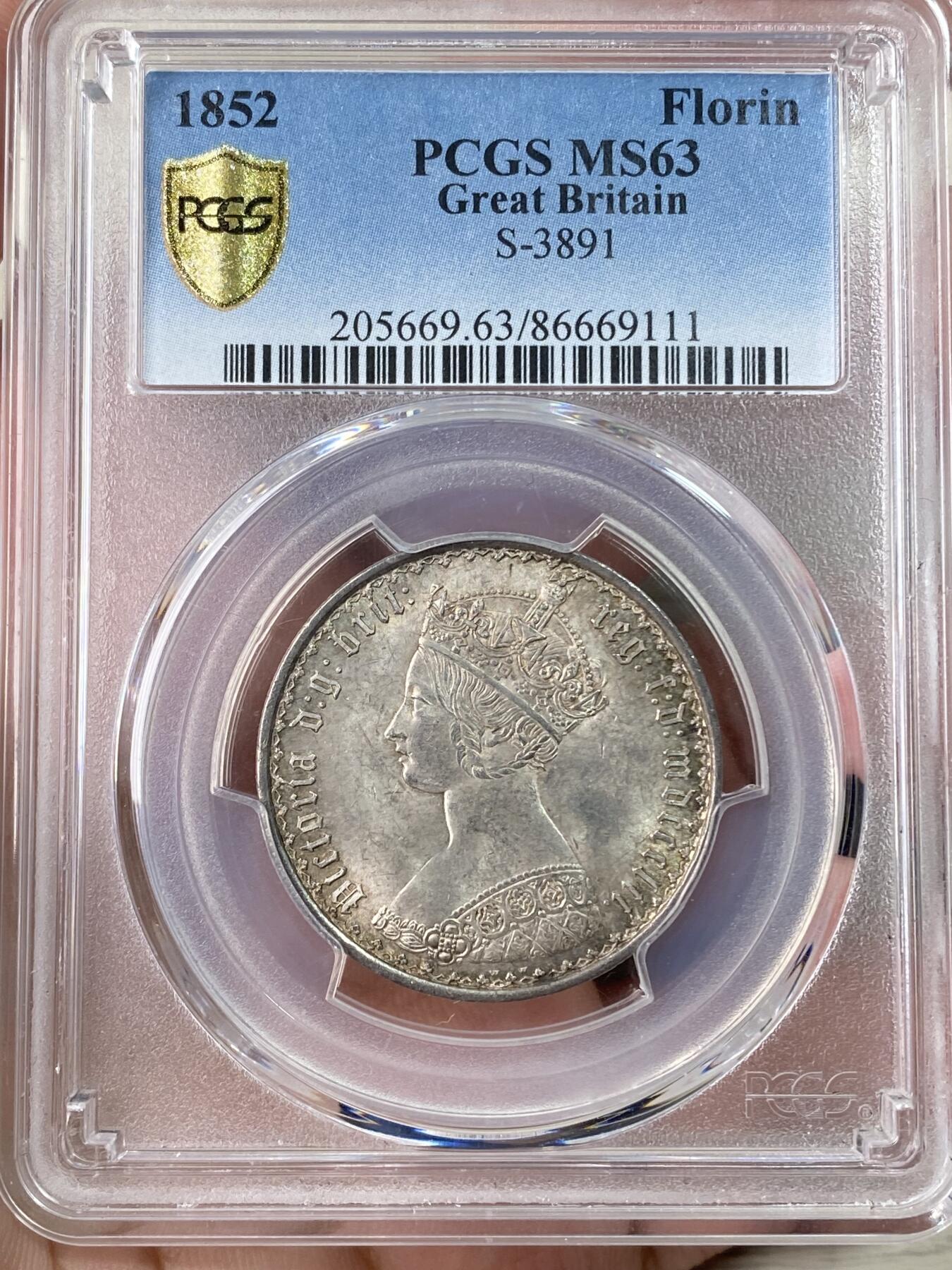 万国钱币拍卖第062期 PCGS MS63 1852年英国维多利亚女皇哥特佛洛林银币 丝绸转光底板香槟淡彩环绕 顶级收藏品质