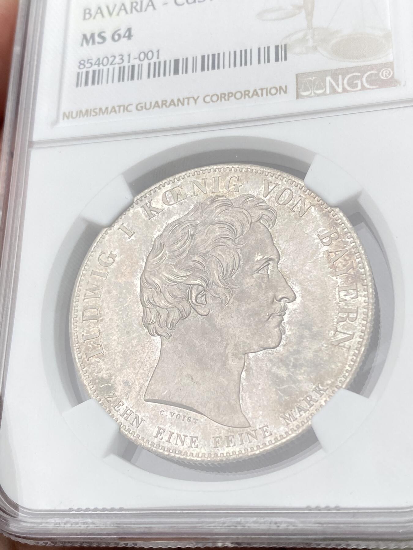 万国钱币拍卖第062期 PCGS MS64 1833巴伐利亚路德维希一世关税同盟历史大泰勒 在历史泰勒四枚关税同盟系列中好品最为罕见的品种 人格化的巴伐利亚女神着一席长袍 左手举丰饶角 右手持墨丘利权杖 寓意新的关税同盟带来贸易与财富 原味欧陆五彩裹身 邮票光泽底板 无可挑剔的一枚典藏级历史大泰勒