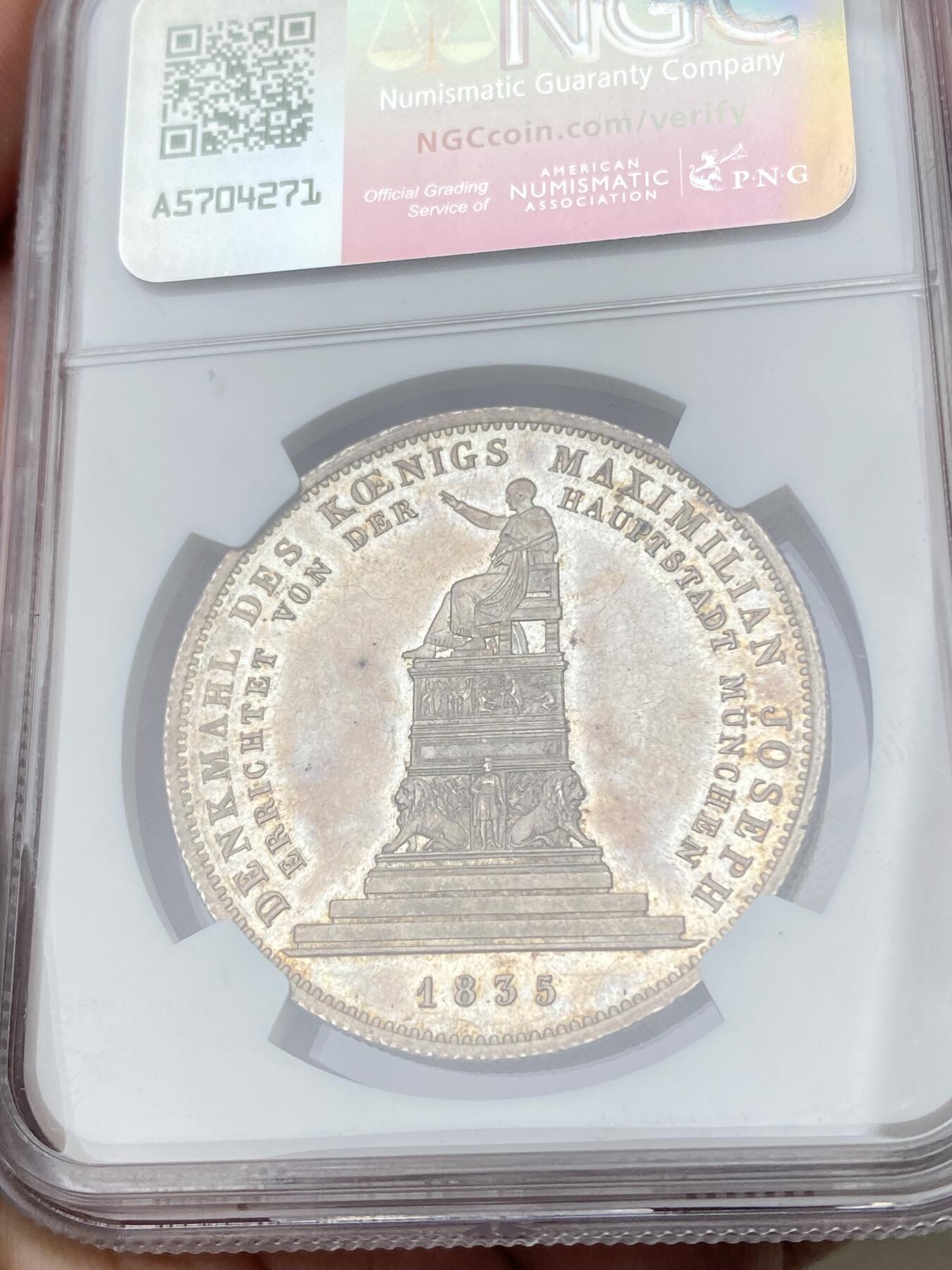万国钱币拍卖第062期 NGC MS61 1835年德国巴伐利亚马克西米利安一世纪念碑落成历史大泰勒 为庆祝马克西米利安一世纪念碑落成 路德维希一世敕令发行此枚历史泰勒加以纪念 老国王身穿蟒袍端坐宝座之上 左手持权杖（此枚为短杖版本）欧陆五彩轻微类镜面质感观感极佳