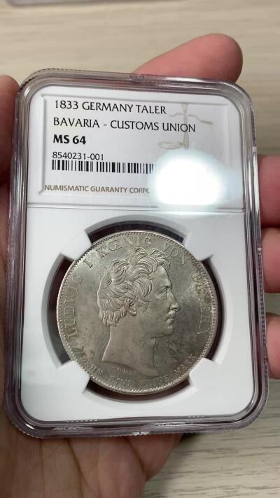 万国钱币拍卖第062期 PCGS MS64 1833巴伐利亚路德维希一世关税同盟历史大泰勒 在历史泰勒四枚关税同盟系列中好品最为罕见的品种 人格化的巴伐利亚女神着一席长袍 左手举丰饶角 右手持墨丘利权杖 寓意新的关税同盟带来贸易与财富 原味欧陆五彩裹身 邮票光泽底板 无可挑剔的一枚典藏级历史大泰勒