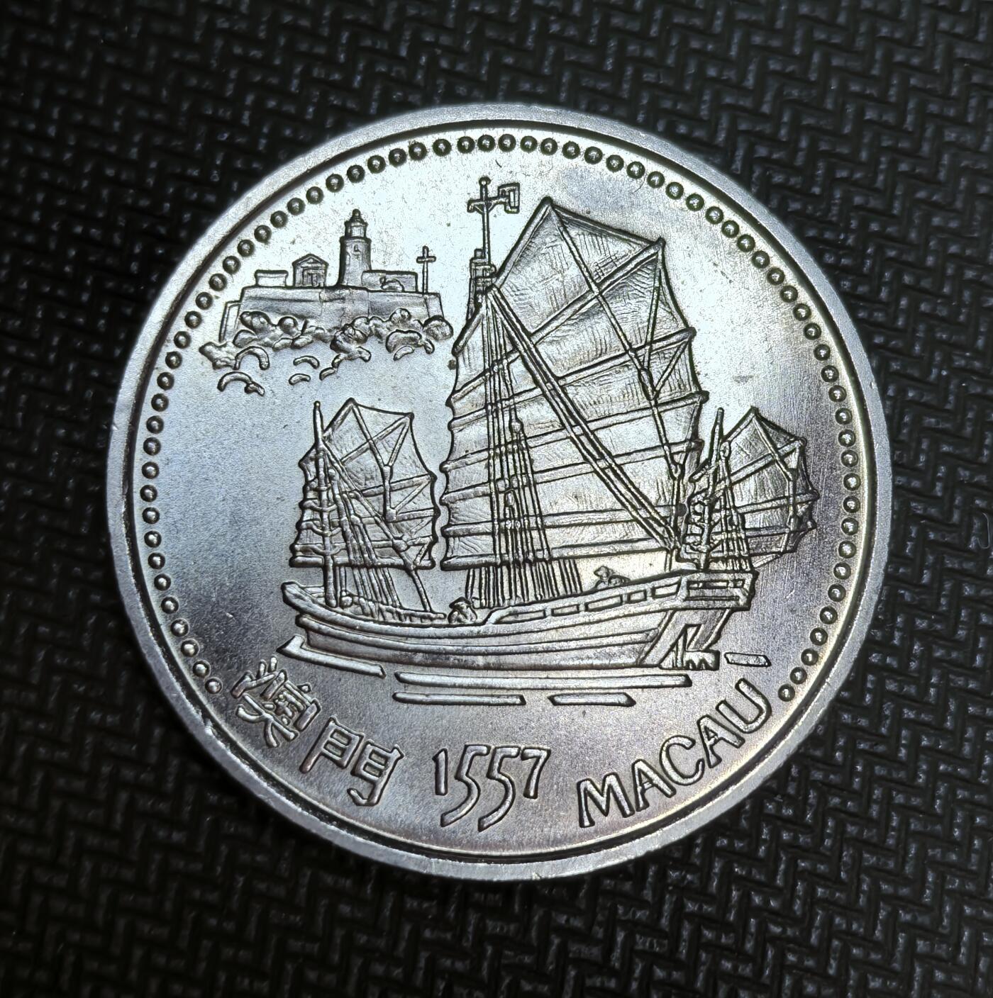 外国优质老铜币银币苏联纪念章，每周六晚九点倒数截拍，满百包邮可寄存，持续收拍 葡萄牙1996年200埃斯库多发现澳门纪念币，纪念 1557 年葡萄牙人定居澳门的历史。正面绘有澳门中式帆船与灯塔，背面以葡萄牙国徽、大三巴牌坊和中国龙，象征中葡文化交融与澳门特殊历史渊源。