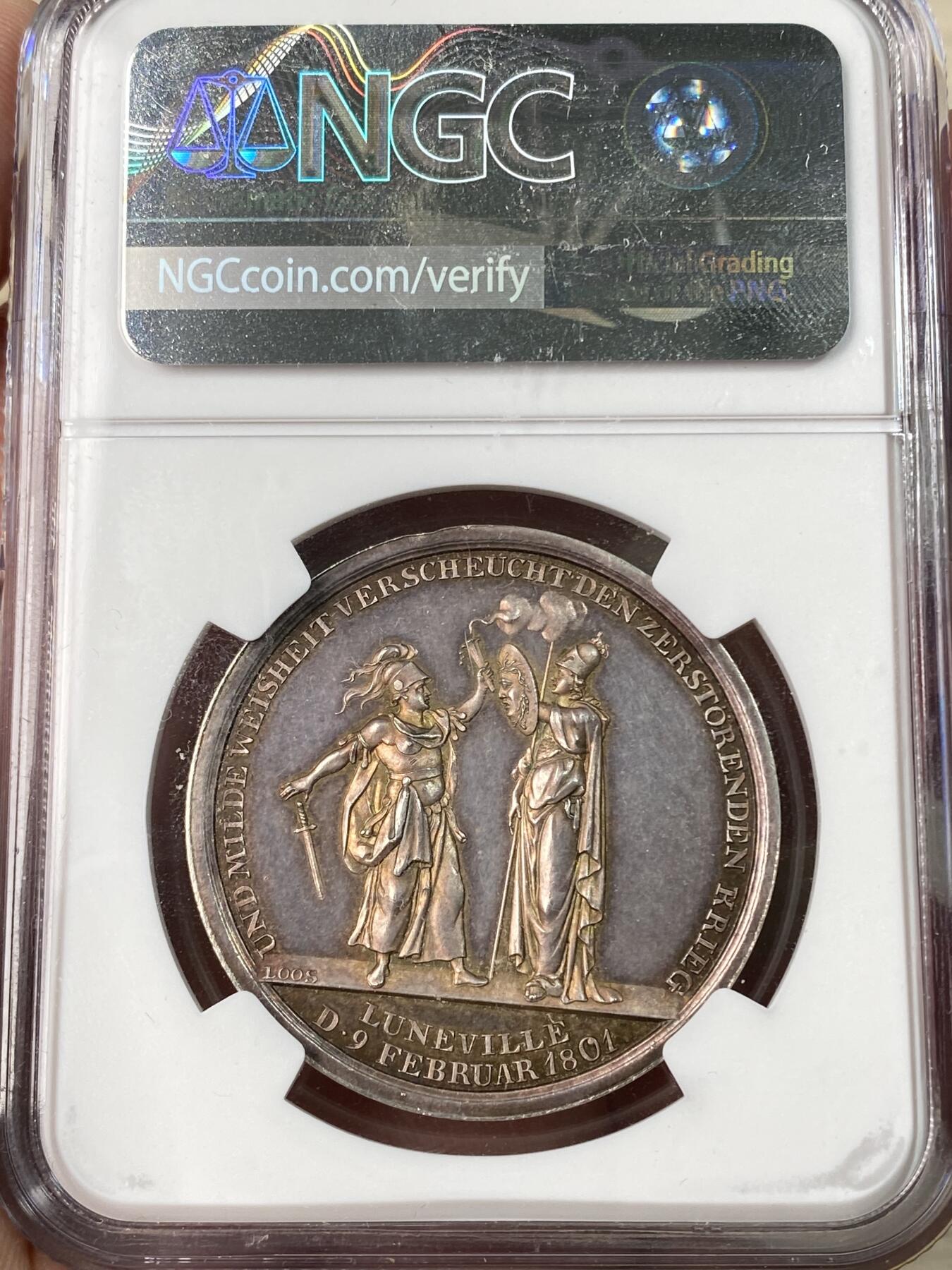 万国钱币拍卖第062期 NGC MS63 1801年德国吕内维尔和平纪念银章 罕见品种 和平女神站在云朵前的地球之上 背面密涅瓦女神向贝洛娜女神伸出埃癸斯盾 贝洛娜女神随即放下了手中剑 彩虹色极美均匀包浆高浮雕收藏品质