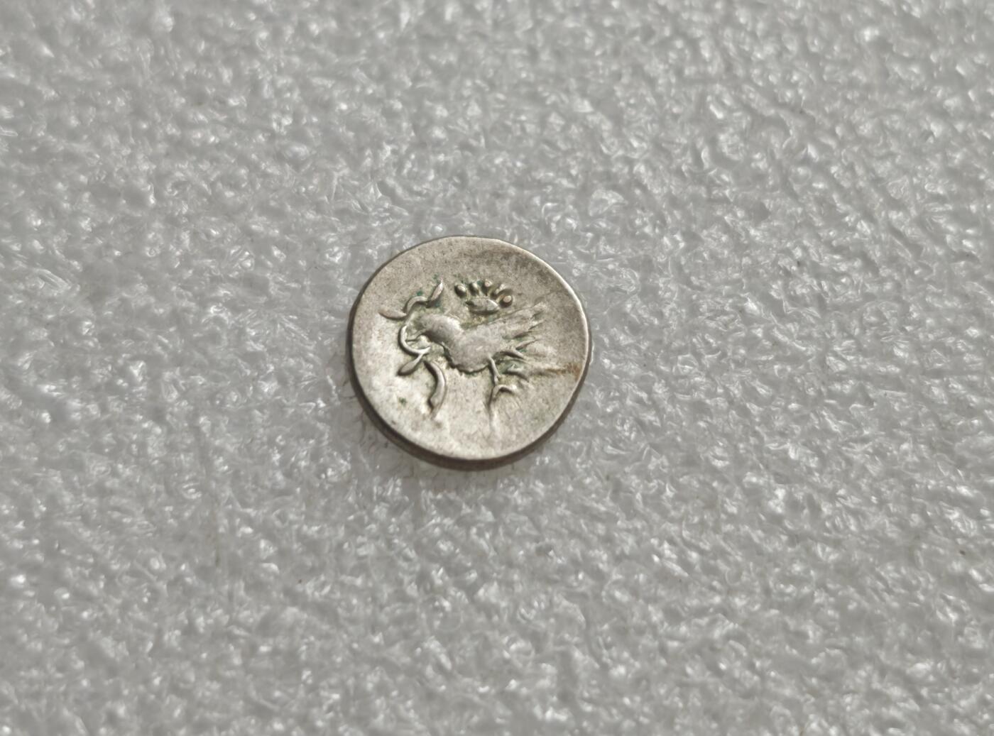 瓶子🏺第232期拍卖会  柬埔寨19世纪红鸟银币（鸡仔钱/1/8泰格尔）图案为哈姆萨神鸟（Hamsa，又称红鸟/恩杜鸟），嘴部叼啄藤蔓/小虫，头顶有冠饰，是高棉民族的图腾象征。 ​红鸟是造物主恩杜的化身，象征吉祥、生命与文明的起源，也代表梵天与智慧女神的座驾