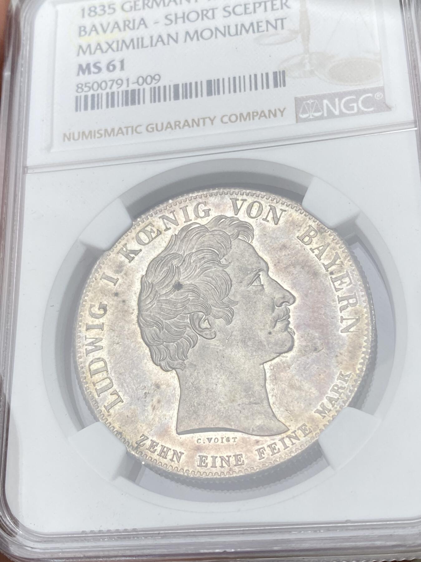 万国钱币拍卖第062期 NGC MS61 1835年德国巴伐利亚马克西米利安一世纪念碑落成历史大泰勒 为庆祝马克西米利安一世纪念碑落成 路德维希一世敕令发行此枚历史泰勒加以纪念 老国王身穿蟒袍端坐宝座之上 左手持权杖（此枚为短杖版本）欧陆五彩轻微类镜面质感观感极佳
