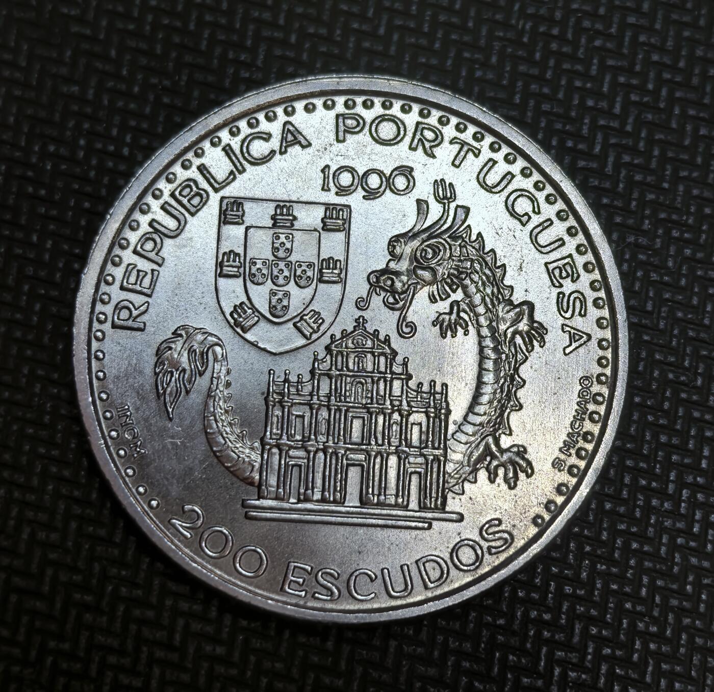 外国优质老铜币银币苏联纪念章，每周六晚九点倒数截拍，满百包邮可寄存，持续收拍 葡萄牙1996年200埃斯库多发现澳门纪念币，纪念 1557 年葡萄牙人定居澳门的历史。正面绘有澳门中式帆船与灯塔，背面以葡萄牙国徽、大三巴牌坊和中国龙，象征中葡文化交融与澳门特殊历史渊源。