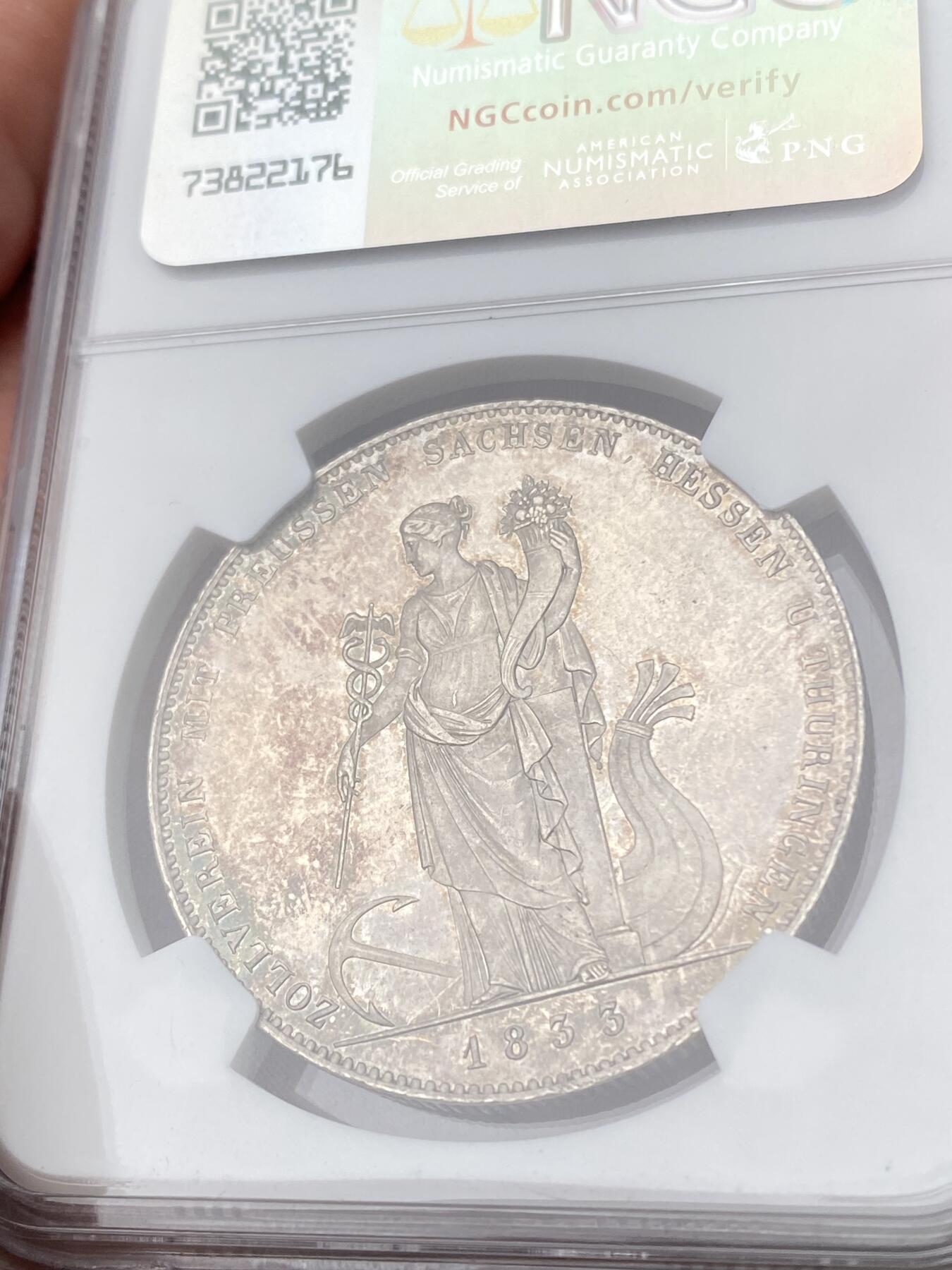 万国钱币拍卖第062期 PCGS MS64 1833巴伐利亚路德维希一世关税同盟历史大泰勒 在历史泰勒四枚关税同盟系列中好品最为罕见的品种 人格化的巴伐利亚女神着一席长袍 左手举丰饶角 右手持墨丘利权杖 寓意新的关税同盟带来贸易与财富 原味欧陆五彩裹身 邮票光泽底板 无可挑剔的一枚典藏级历史大泰勒