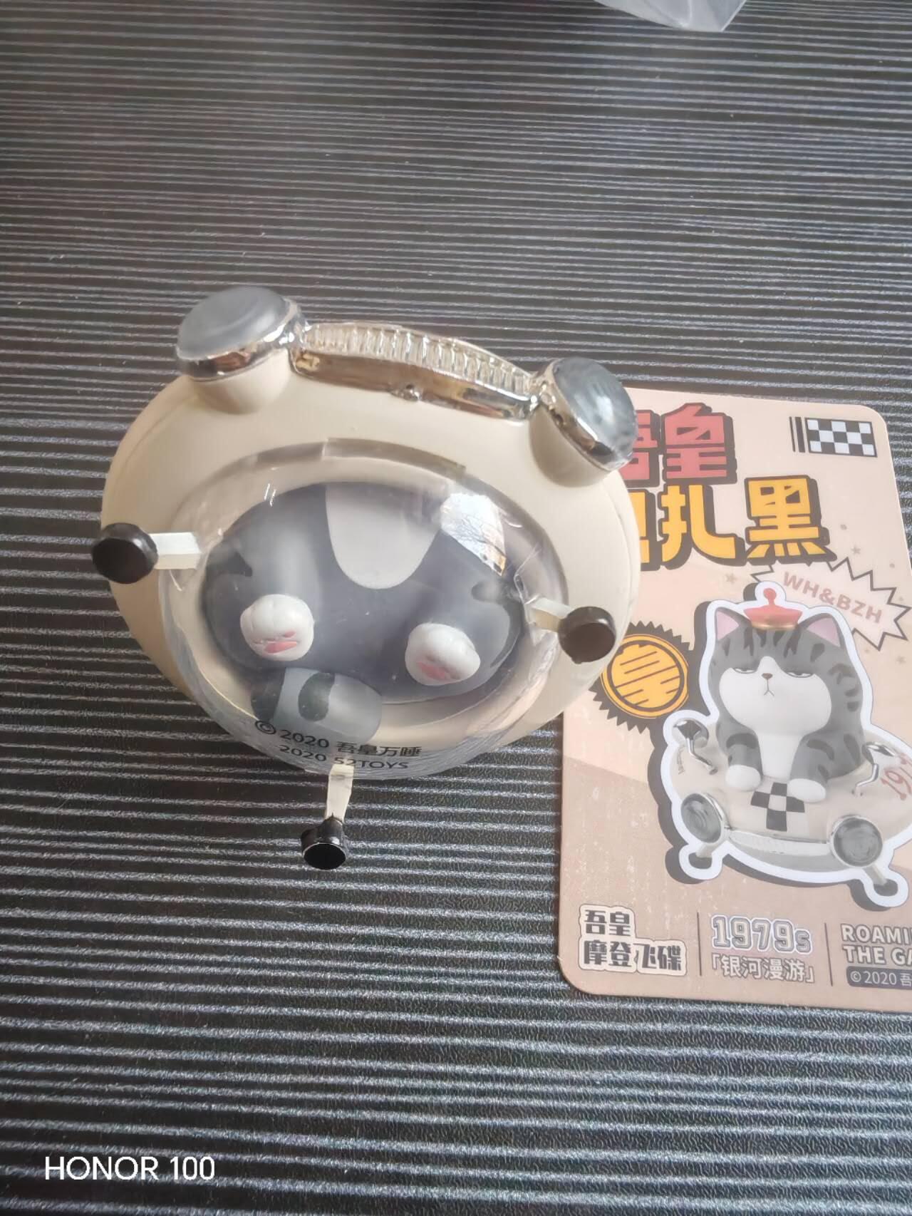 正版盲盒专场 吾皇万睡「银河漫游」系列盲盒 中的「摩登飞碟」款手办。核心角色「吾皇」是一只傲娇的美短虎斑猫，这款将其与复古飞碟结合，打造出“喵星人驾驶飞碟”的趣味设定。