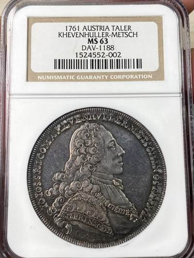 万国钱币拍卖第063期 - NGC MS63 1761年奥地利哈布斯堡领地-赫文胡勒-梅奇-约翰·约瑟夫伯爵纹章大泰勒 极罕见神罗小邦品种 币面附着极致美丽的欧陆玫瑰色调包浆 拉长的倒影意味着此枚钱币从未动过的原始状态 戴头盔的双狮簇拥着繁复华丽的家族盾徽 伯爵的一头卷发几乎看不出任何磨损痕迹 NGC老白盒 错过即无的顶级神罗小邦精品泰勒