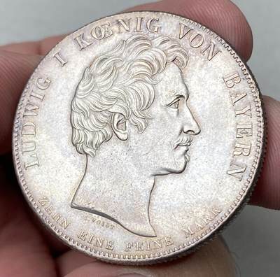 万国钱币拍卖第062期 - 1825年德国巴伐利亚路德维希一世加冕纪念历史大泰勒  历史泰勒系列开山之作 记录了国王路德维希一世登基加冕克承大统的重要时刻 路一身穿金丝镶边华服 颈戴十字架吊坠 左手握剑 右手持权杖 置于桌面的宪法之上 手边还有王冠一顶  德系历史泰勒名品